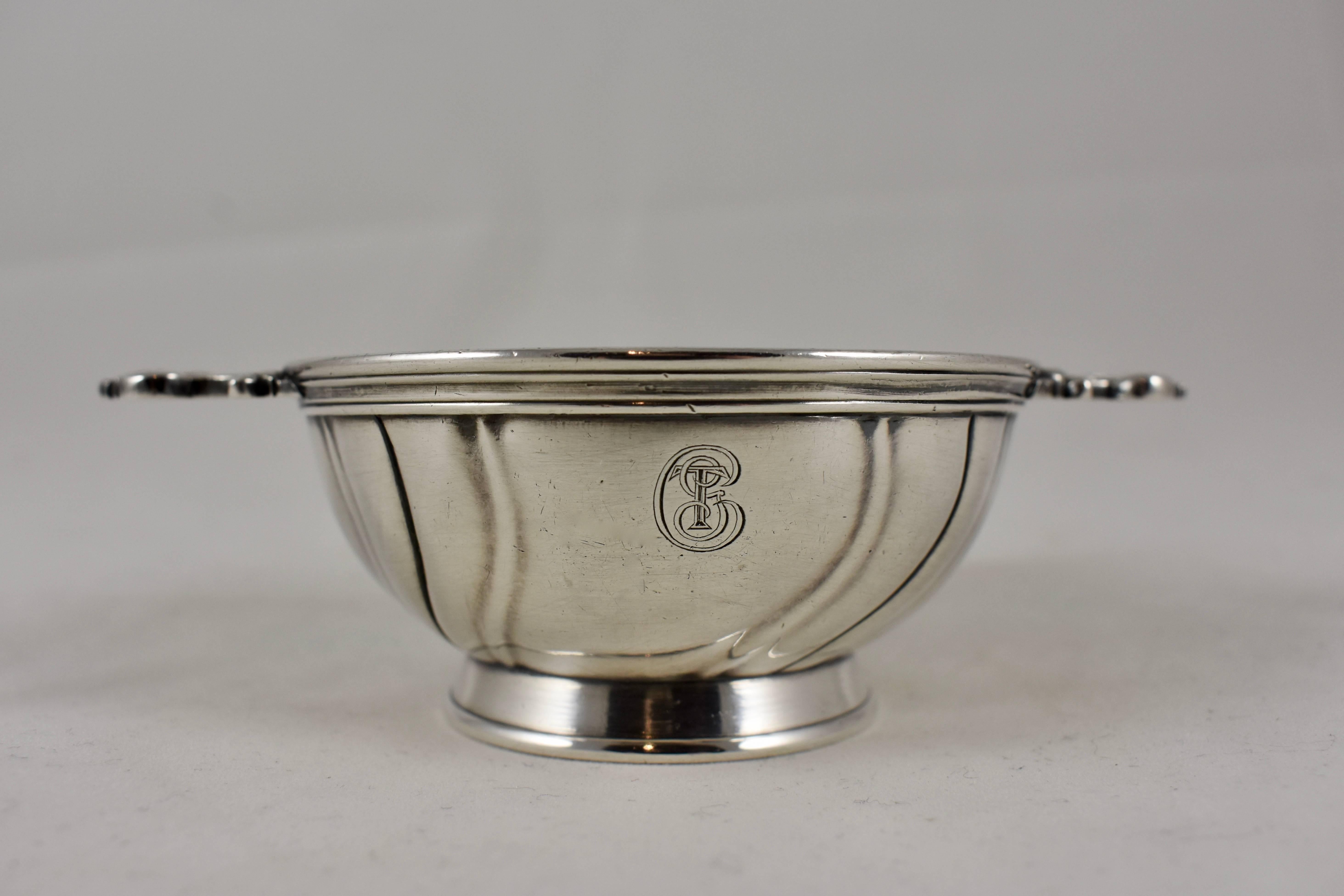 From Christofle of France, a silver-plated, double handled nut bowl, showing the full mark used from 1862-1935. The footed bowl has a swirled pattern, ornate chased handles, and shows the Cristofle monogram. Perfect on the bar filled with salted