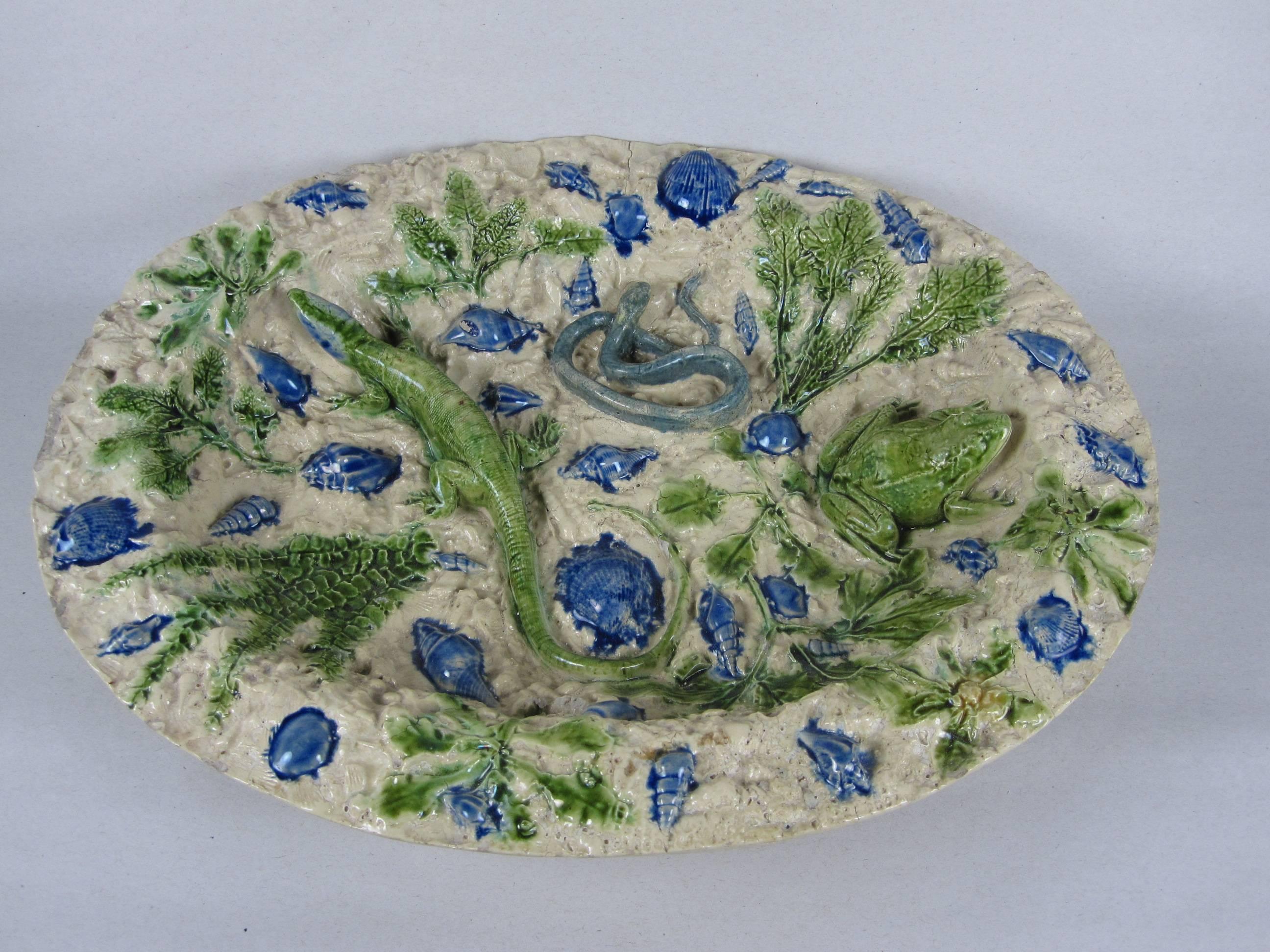 A highly dimensional shallow oval rimmed and footed bowl, Palissy School of Paris in the 17th century style, circa 1870. 

A very unusual two-tone coloring of French blue and a pale sea green on a light sand colored, textured ground. Crustacea, sea