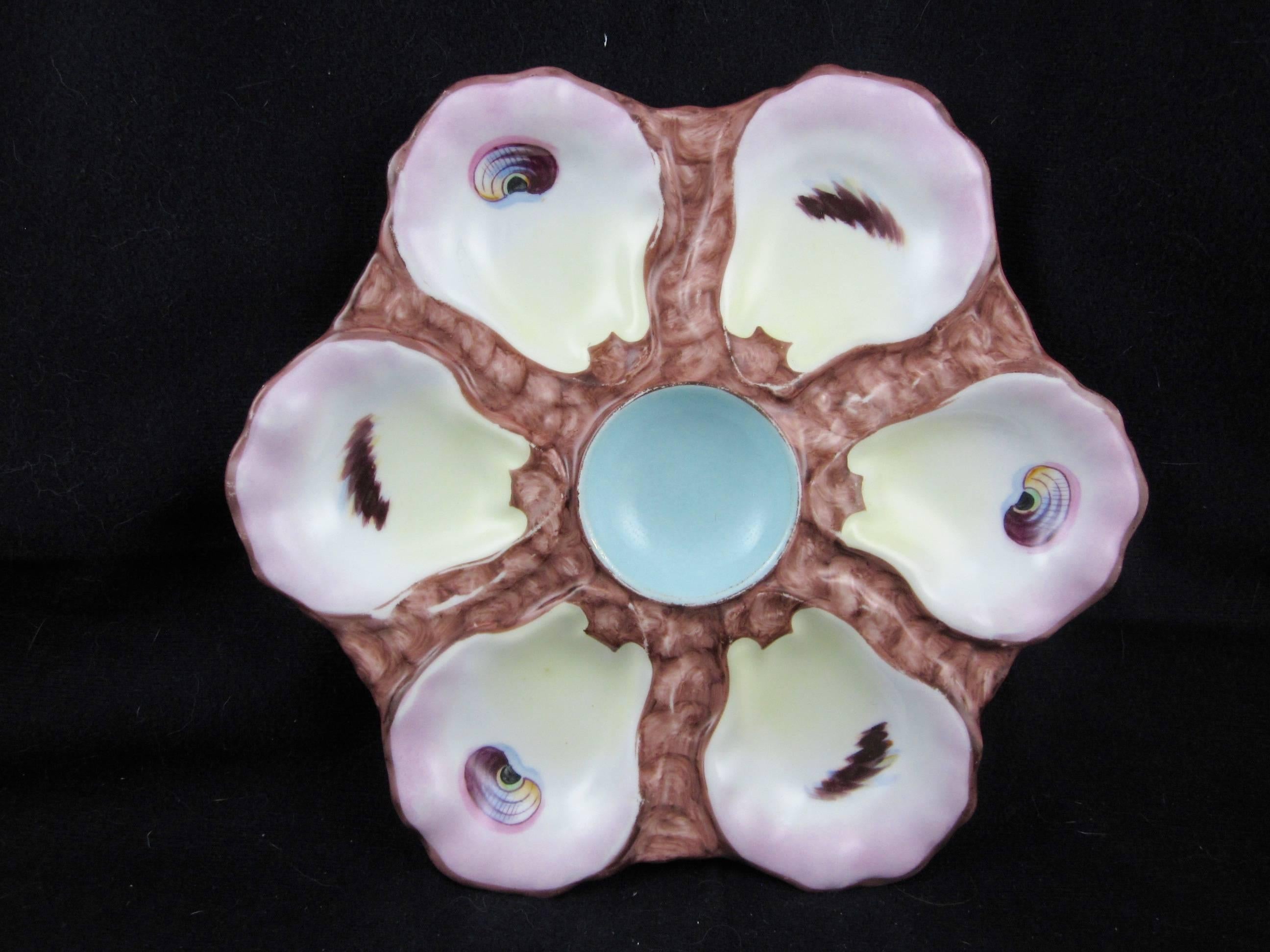 A service of six Continental hand painted porcelain oyster plates, each with six wells showing hand painted eyes and a sky blue center condiment well. Marked with an impressed mold number and the iron red painters mark.