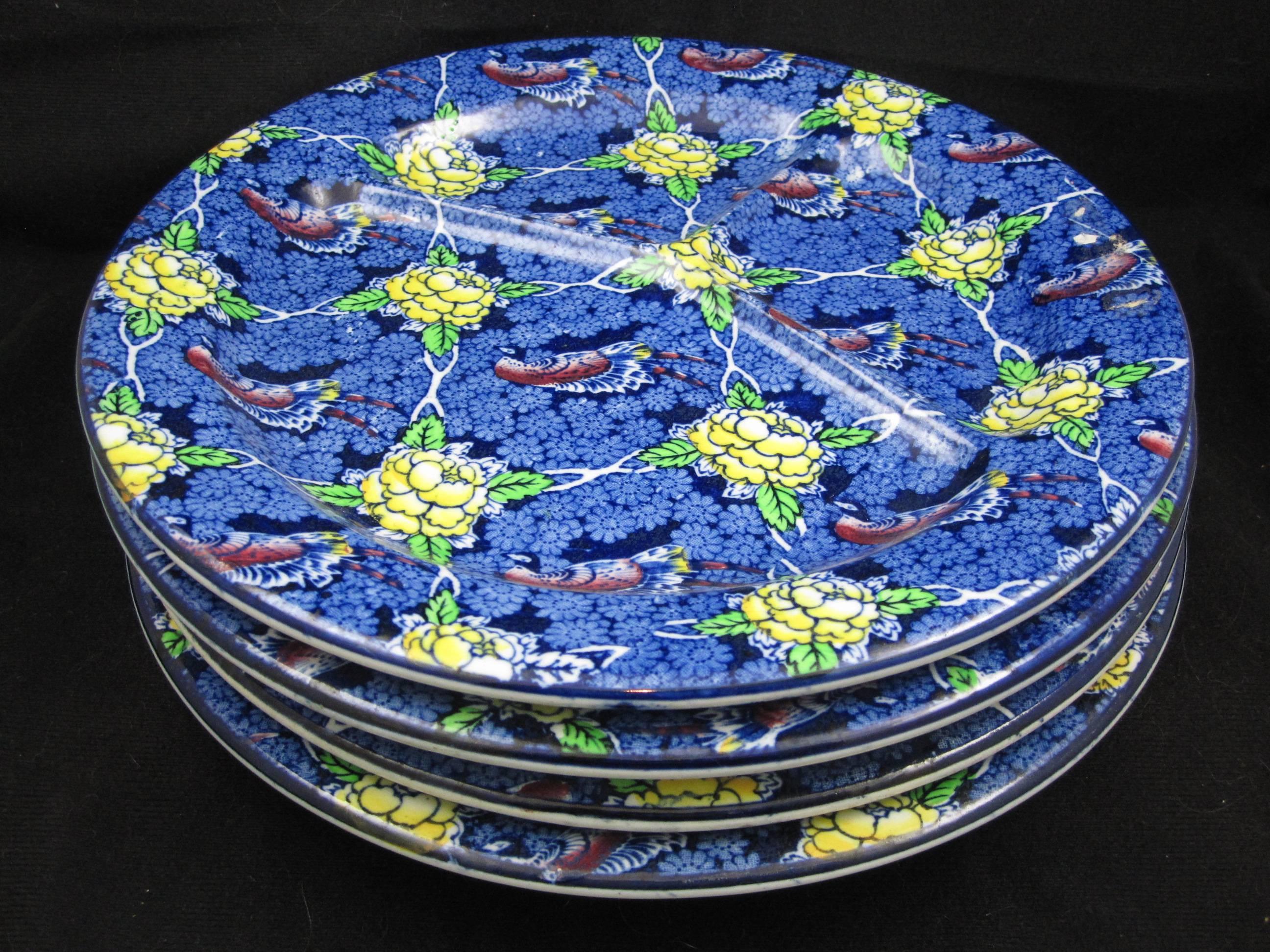 A set of four Staffordshire ironstone chop grill plates produced by Brown & Steventon, Burslem, England, circa 1910. An overall chintz sheet pattern transfer of birds against a lattice of yellow flowers on a cobalt blue floral ground. The heavy