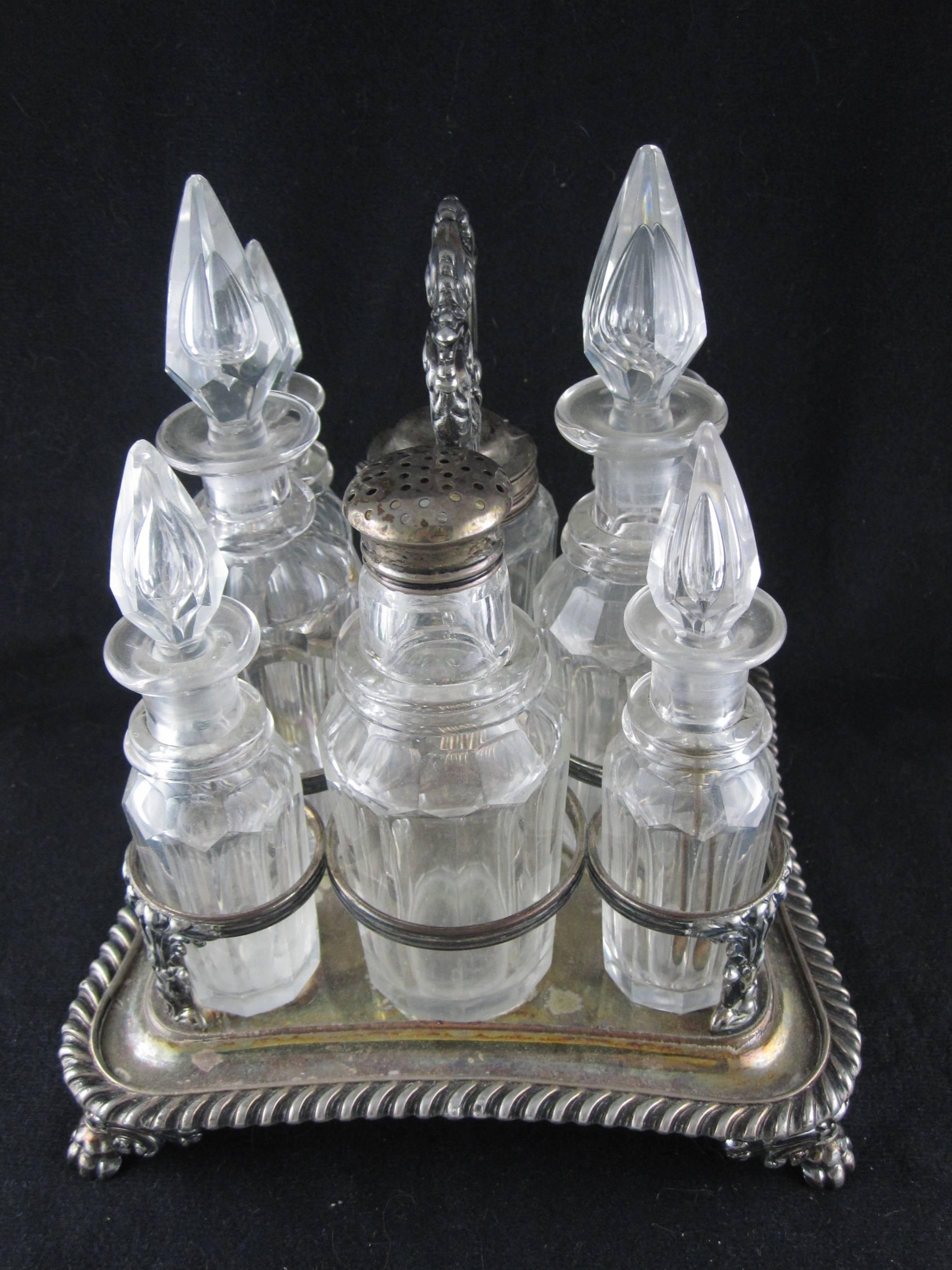 An English Victorian condiment and cruet set consisting of a stand fitted for eight paneled glass bottles with faceted stoppers. This is a heavy, oversize stand with castors for mustard, catsup, oil, vinegar, Worcestershire sauce, malt vinegar,