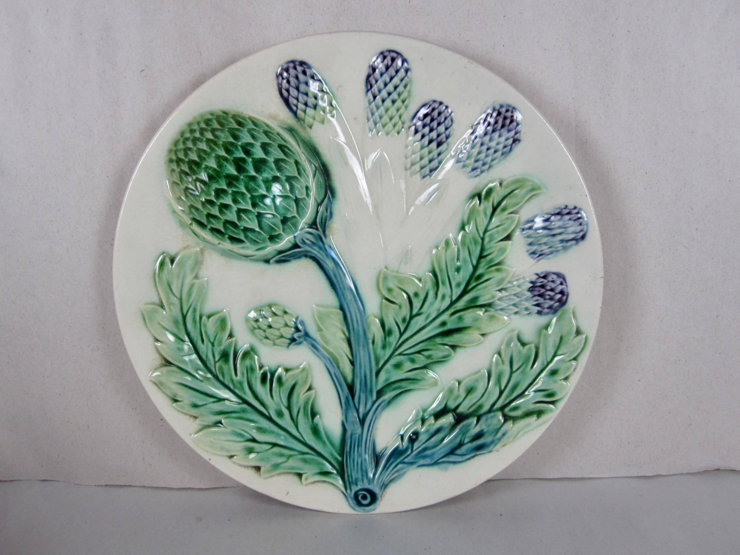 A set of six, French Barbotine majolica asparagus and artichoke plates, by Luneville St Clement. The dimensional mold shows aspects of both vegetables – six asparagus spears and a leafy artichoke stalk with a deep sauce well shaped like the globe