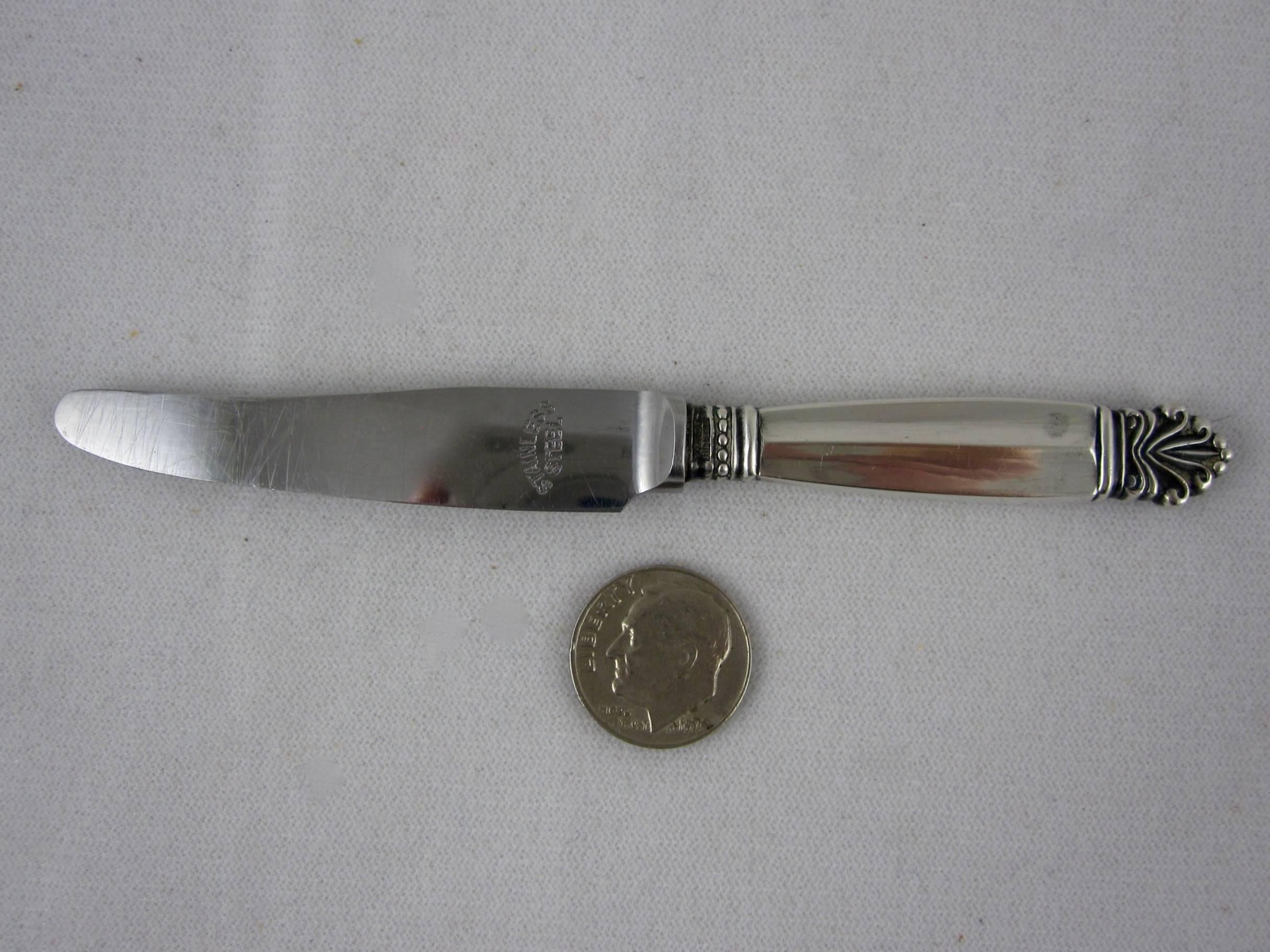 A sterling silver child’s knife or small spreader, Georg Jenson, in the Acanthus pattern designed by Johan Rohde in 1917. A small and scarce piece, a U.S. dime is pictured to show scale.

The collar shows the makers mark and sterling, the blade is