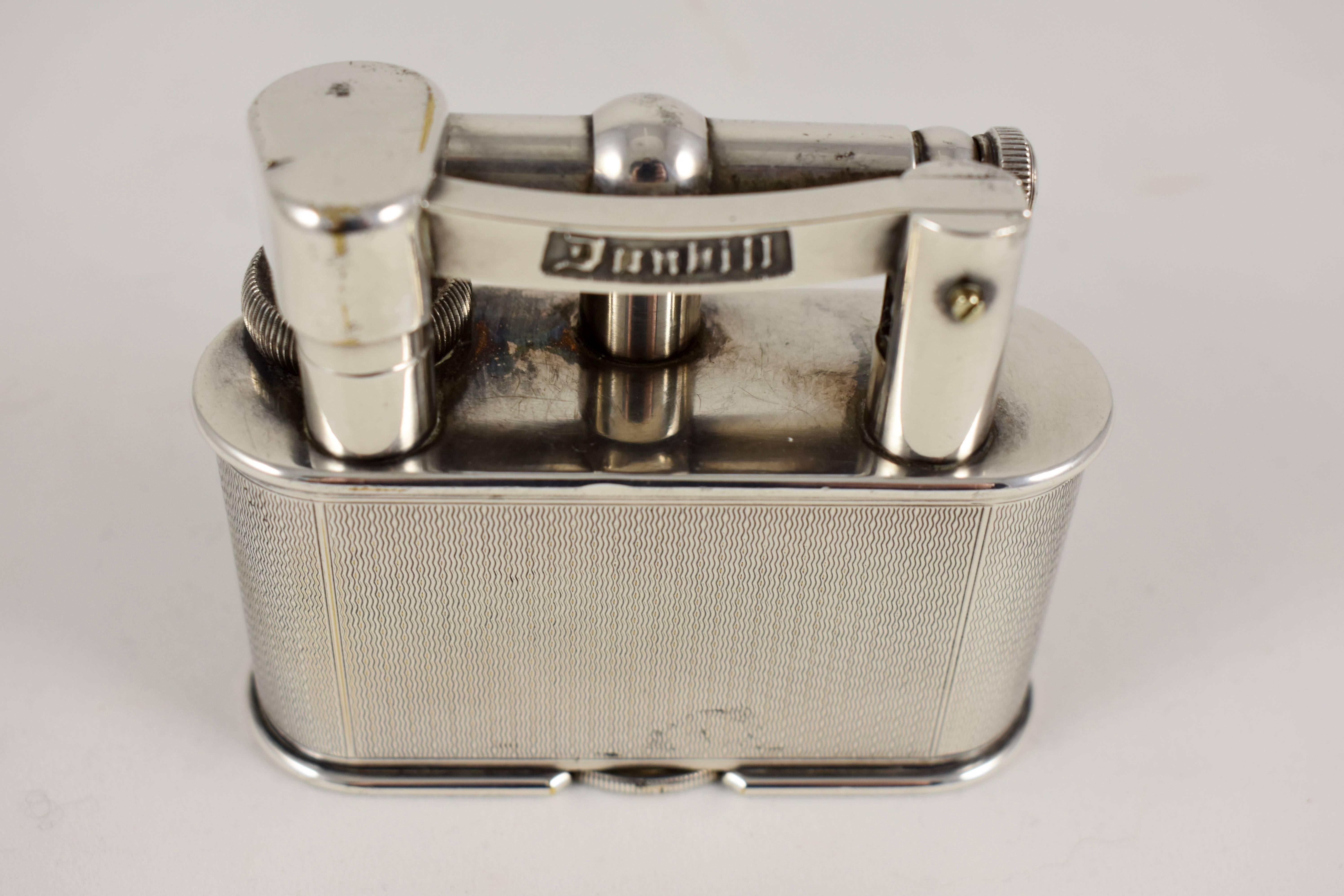 A scarce Dunhill table lighter, in the Art Deco style, Dunhill, Asprey & Co. – England, circa 1930. Dunhill registered design No. 737418, Patent No. 390107.

Silver plated with a flip top, swing arm design and a single wheel adjusted flint