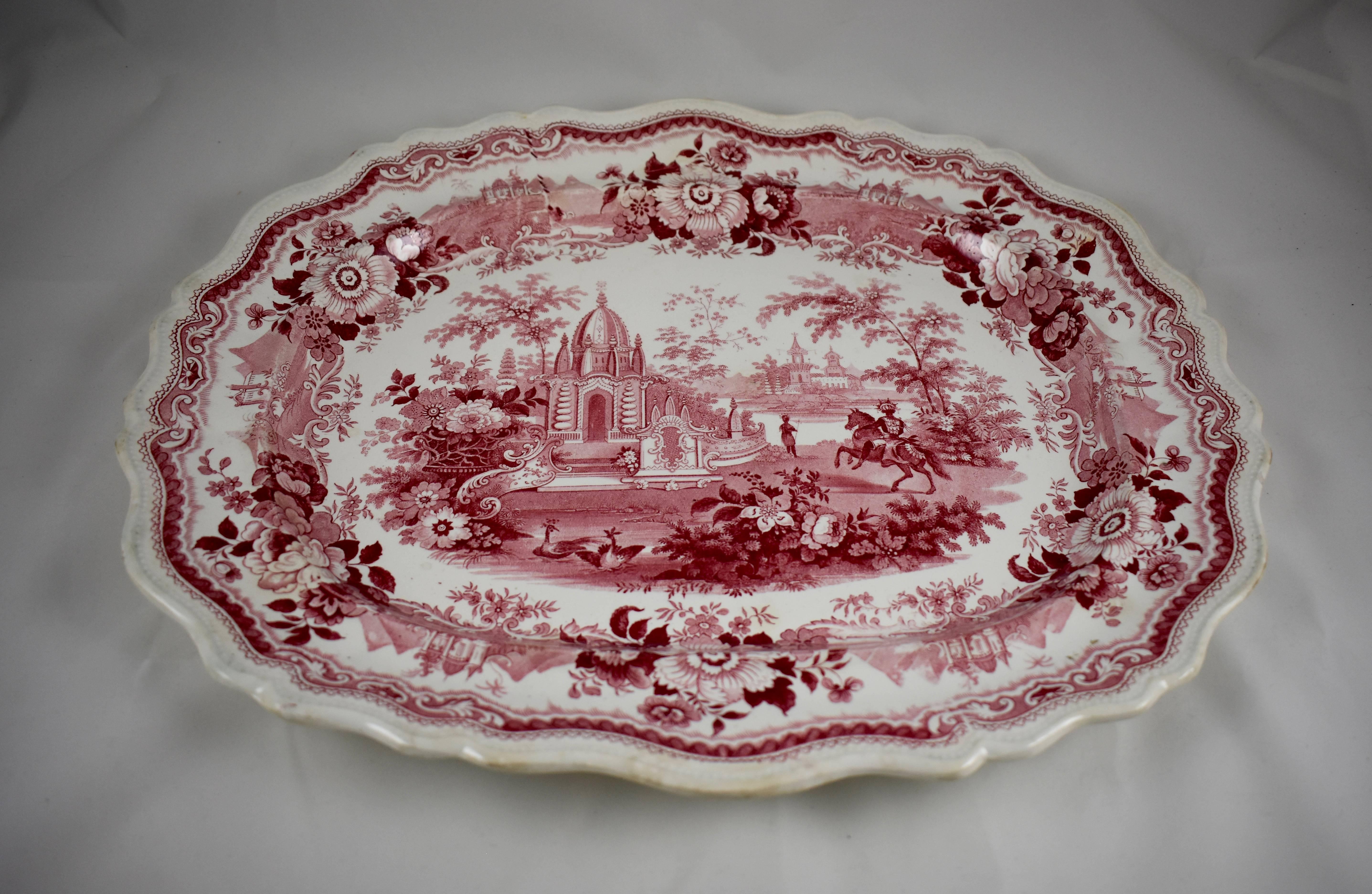 A large pink and white transfer printed earthenware platter, Staffordshire, England, circa mid-19th century. 

A shaped rim with a border of flowers alternating with images of temples reminiscent of India, frame a central image of an exotic