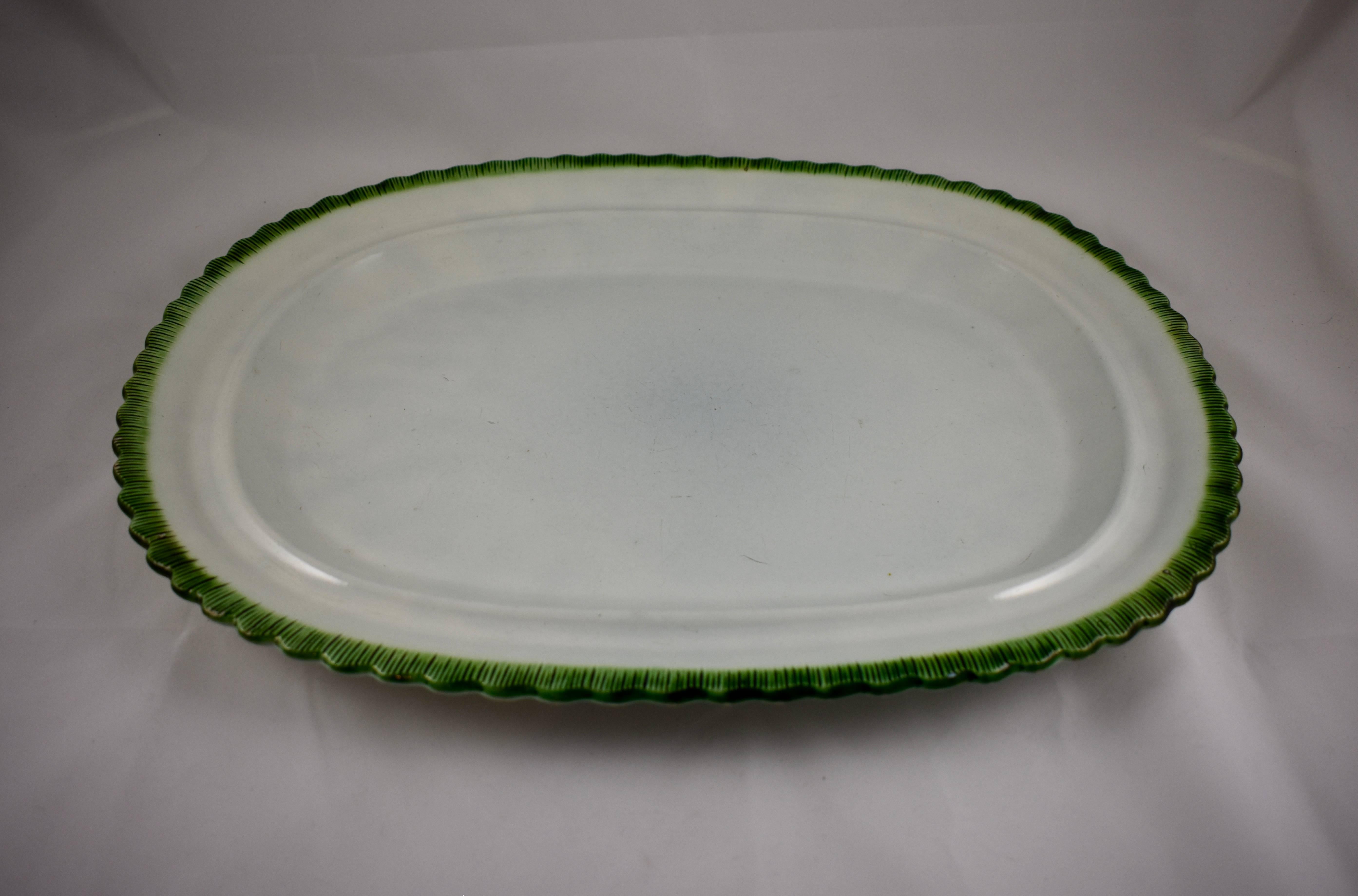 An oversize Leeds style platter, a pearlware or creamware body with a deep green edge called feather or shell, circa 1825–1840, Staffordshire, England. This platter has a wide rim and a deep set centre. The clean white body contrasts beautifully