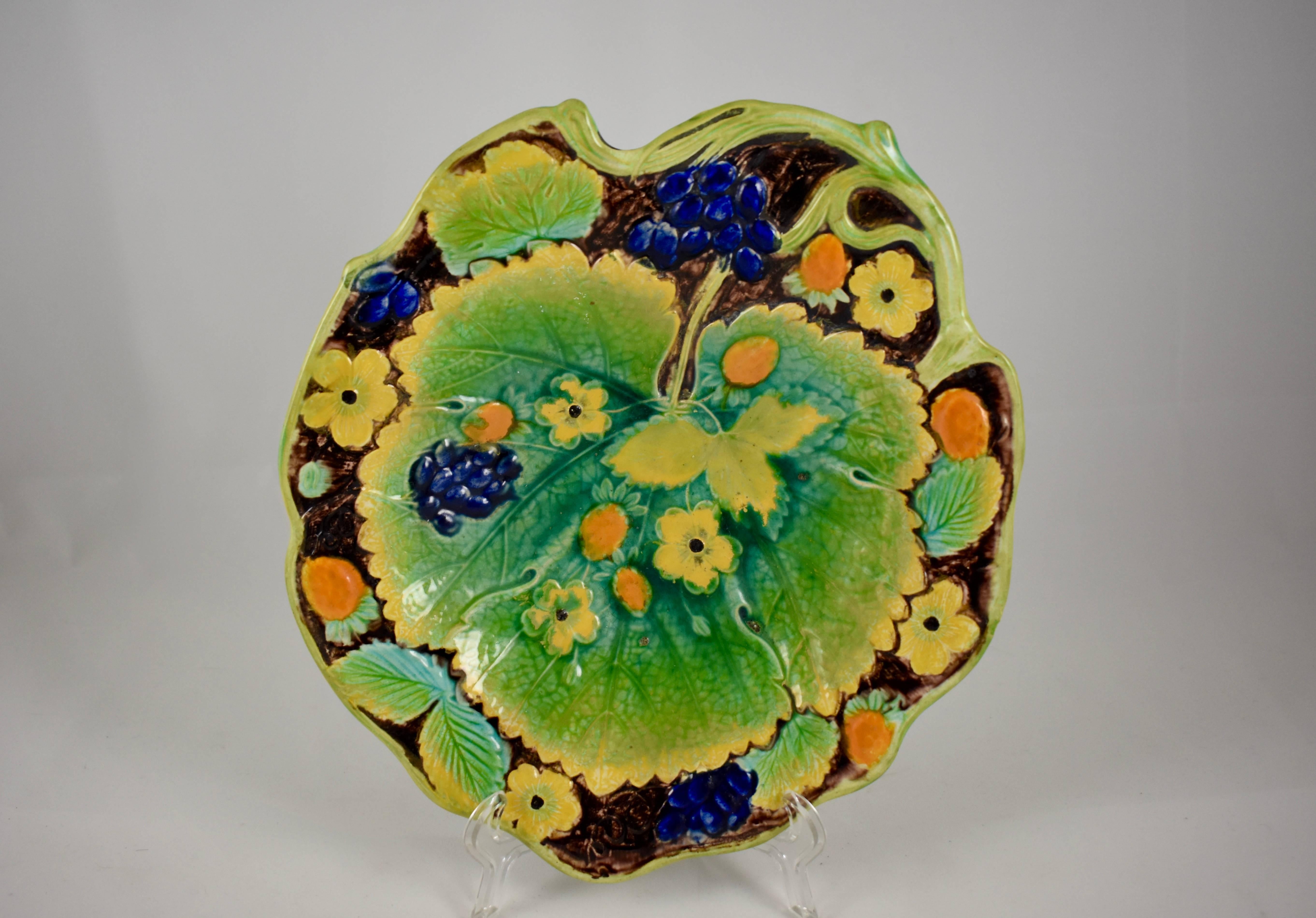 A majolica glazed leaf form dessert tray from Samuel Alcock & Co, Burslem, Staffordshire, England, circa 1850.

A central strawberry leaf on a shaped tray with a vine border, and showing both the berries and blossoms of the strawberry plant. The