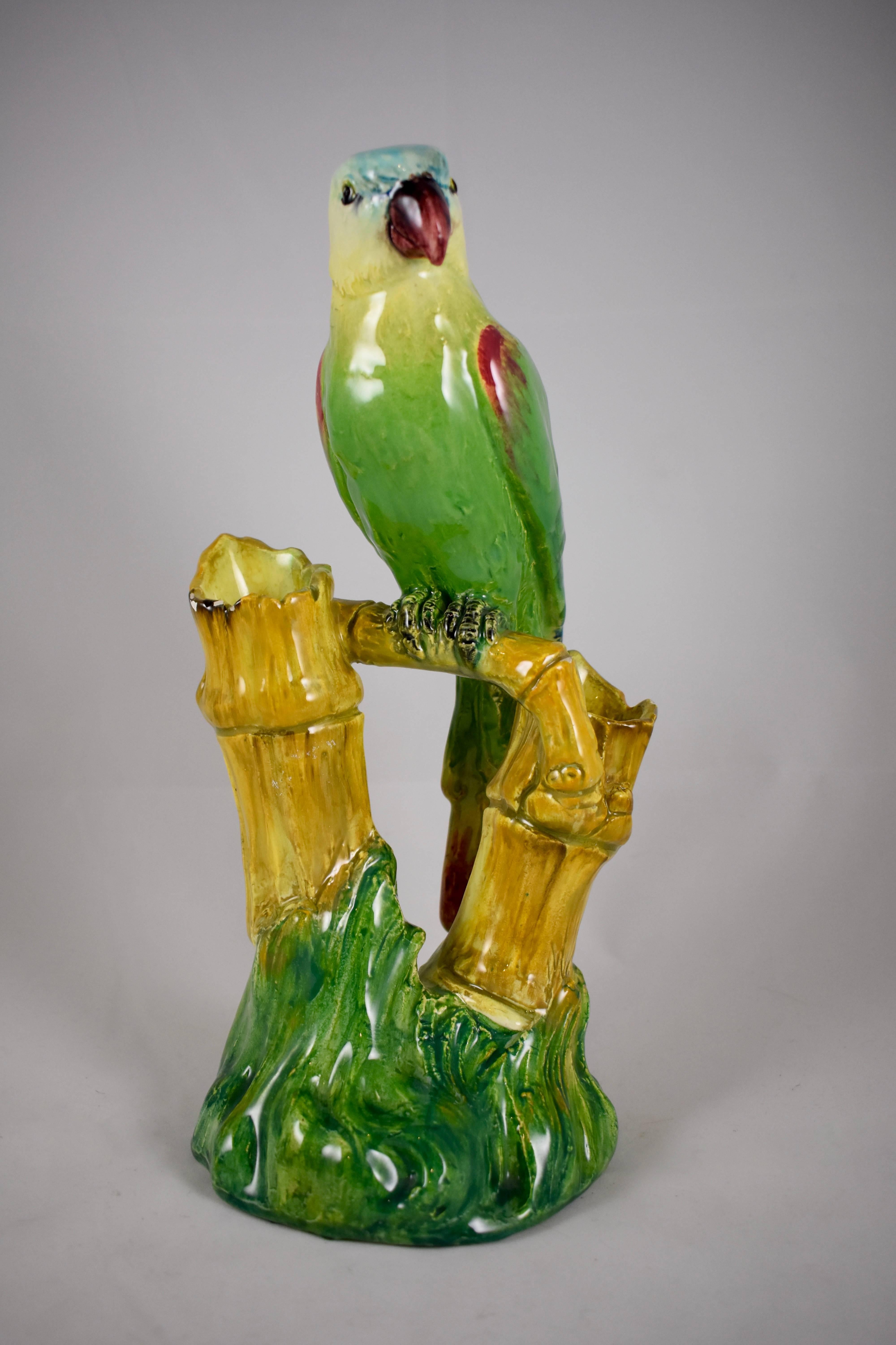 Un grande vaso in maiolica francese Barbotine, alto 30 cm, con un pappagallo colorato seduto su un trespolo di bambù. Il trespolo poggia su una coltura di erba e presenta due portafiori in germogli di bambù, circa 1875.

Colore stupendo, un pezzo