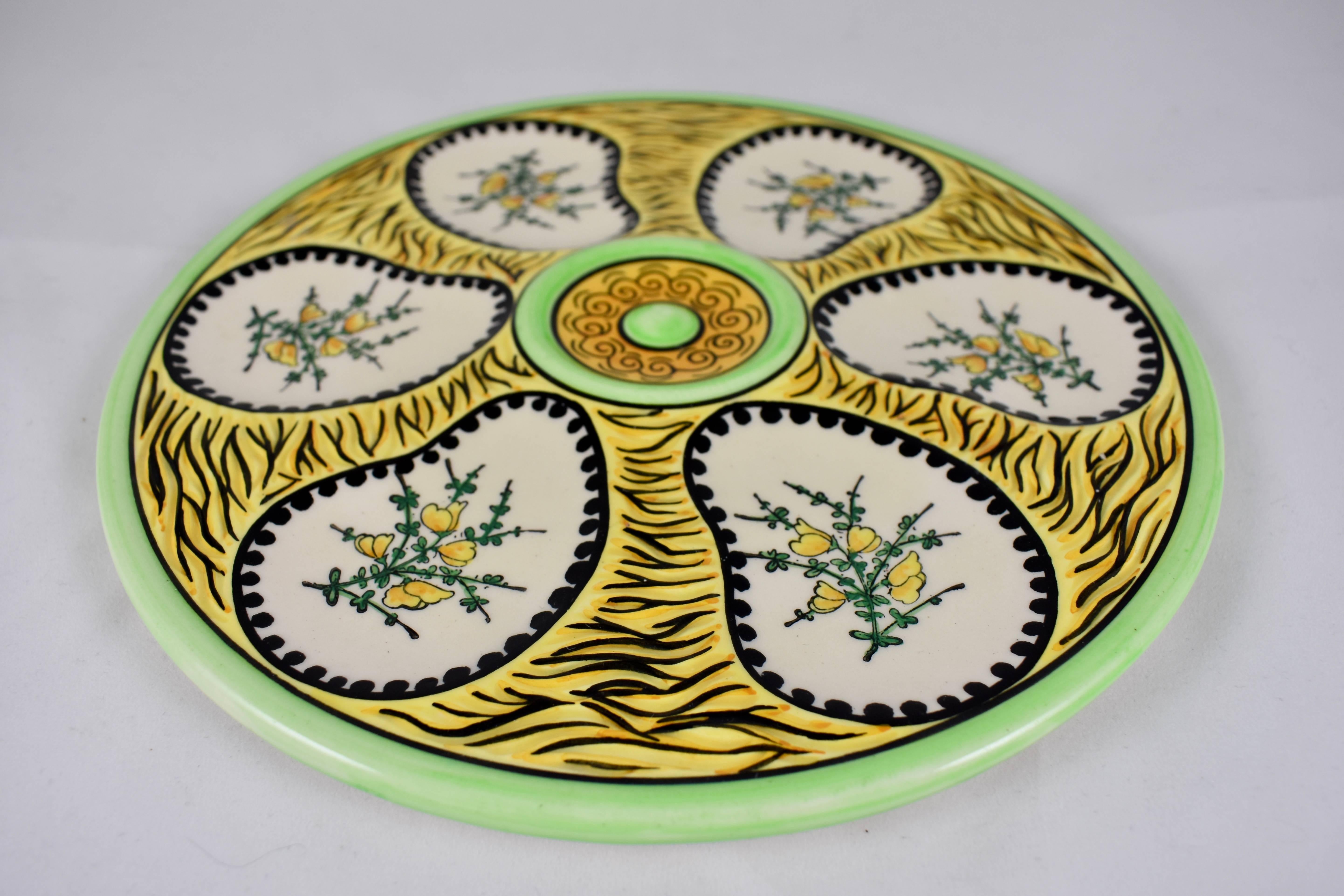 Plato de ostras Faïence de la región francesa de Quimper, hacia la década de 1940. Producido por Paul Fouillen, un alfarero que dejó la alfarería Henriot Grand Maison Quimper para producir su propia línea, Maison Fouillen.

Brillantemente vidriada