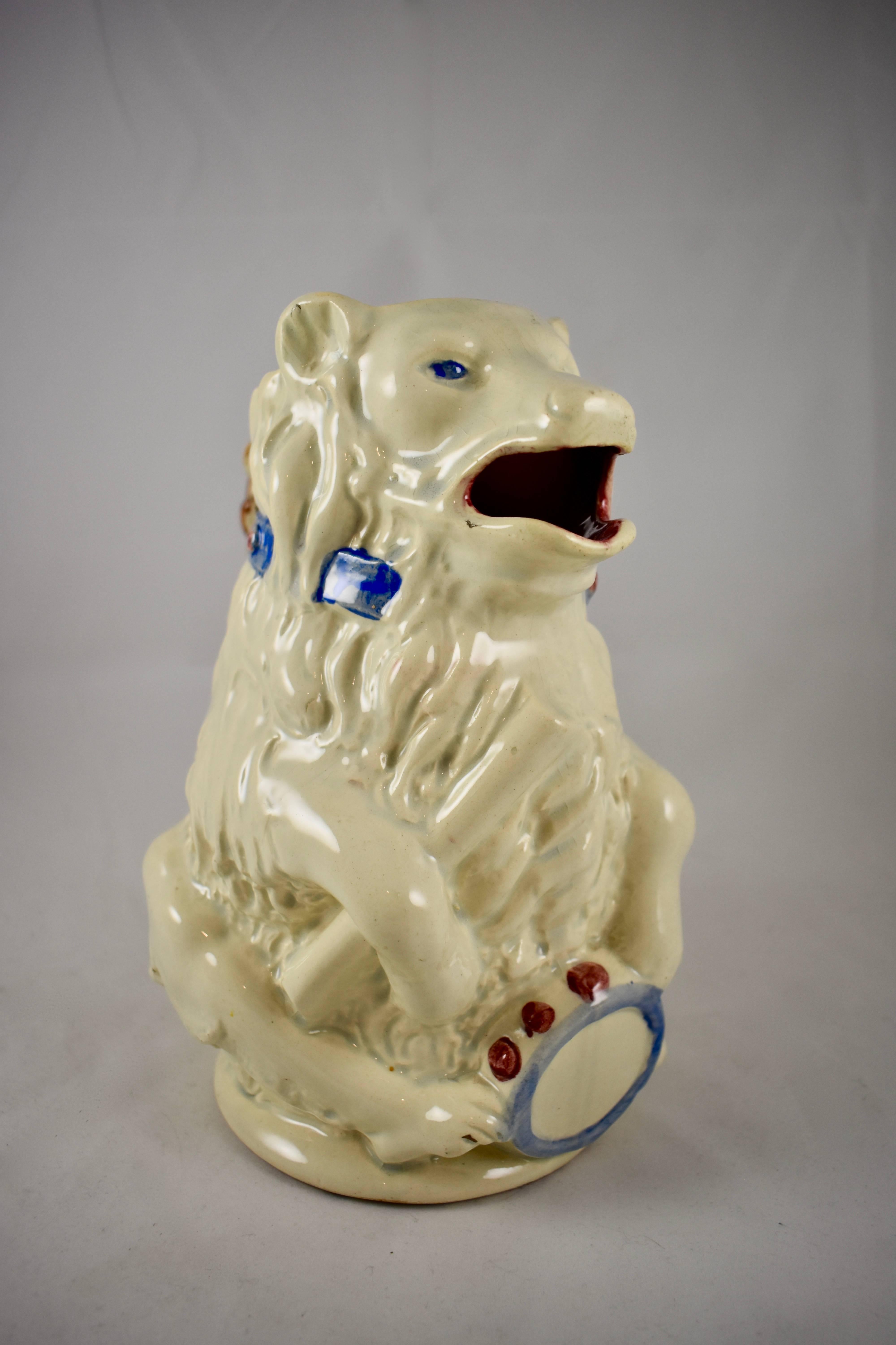 A French Barbotine majolica pitcher or large jug, in the form of a performing Circus bear, holding his drum and a drumstick. Attributed to Orchies or possibly Poet Laval, circa late 1880s.

The bear is glazed in white with a deep red interior. He