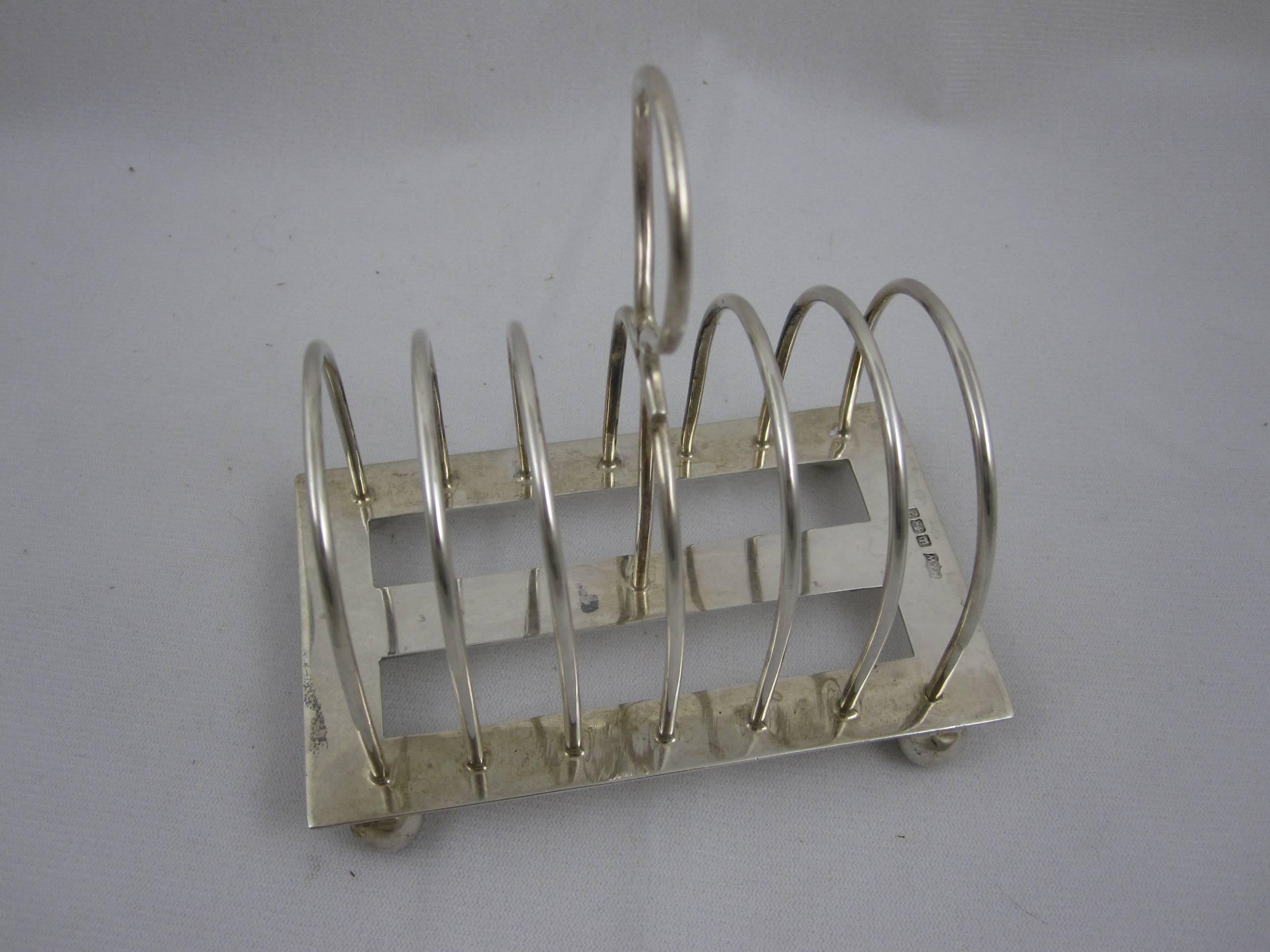 An Victorian English sterling silver toast rack, often used today as a desk top letter holder or mail sorter. 

A toast rack with six slots, a ring shaped toting handle and ball feet. Showing the hallmarks for Mappin & Webb, Sheffield, England,