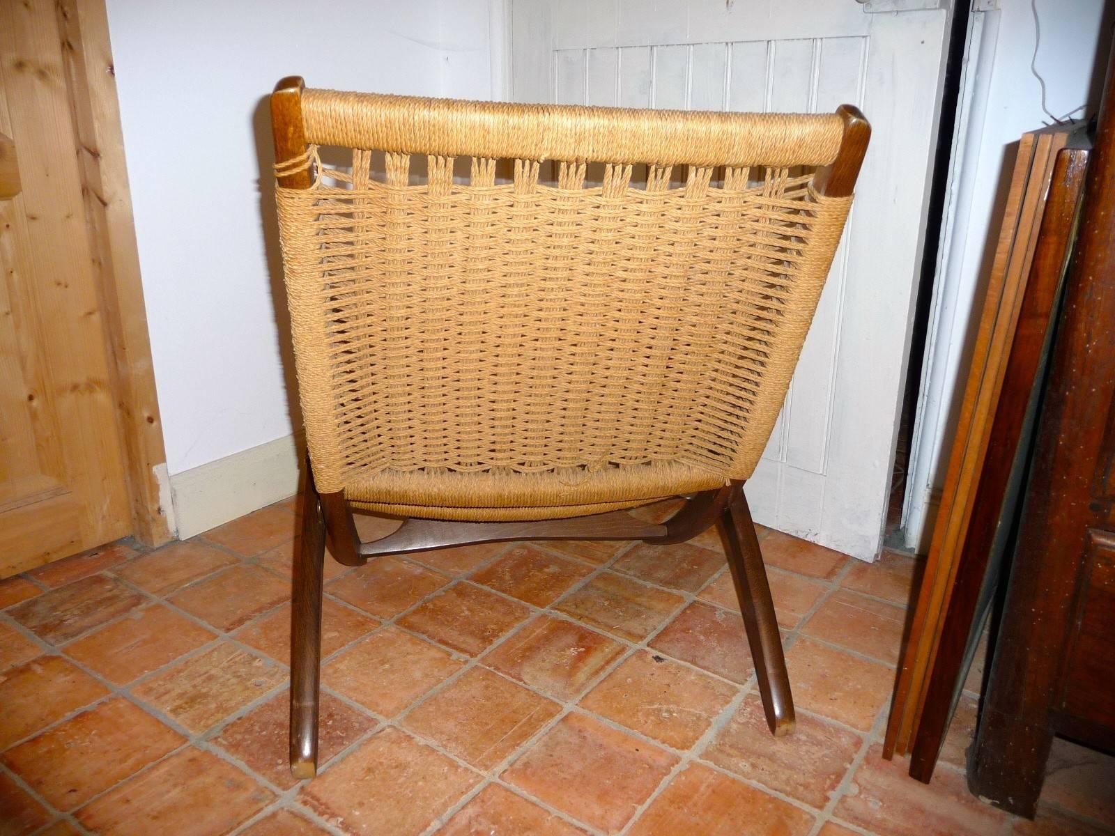 Elegant folding chair of teak No. 512, circa 1949 structure forming two arcs, seat fitted with flat butts in front, Miss shaped sliding seat support mobile spacer into the inner edges of the seat dug for this purpose, caned seat and back (original)