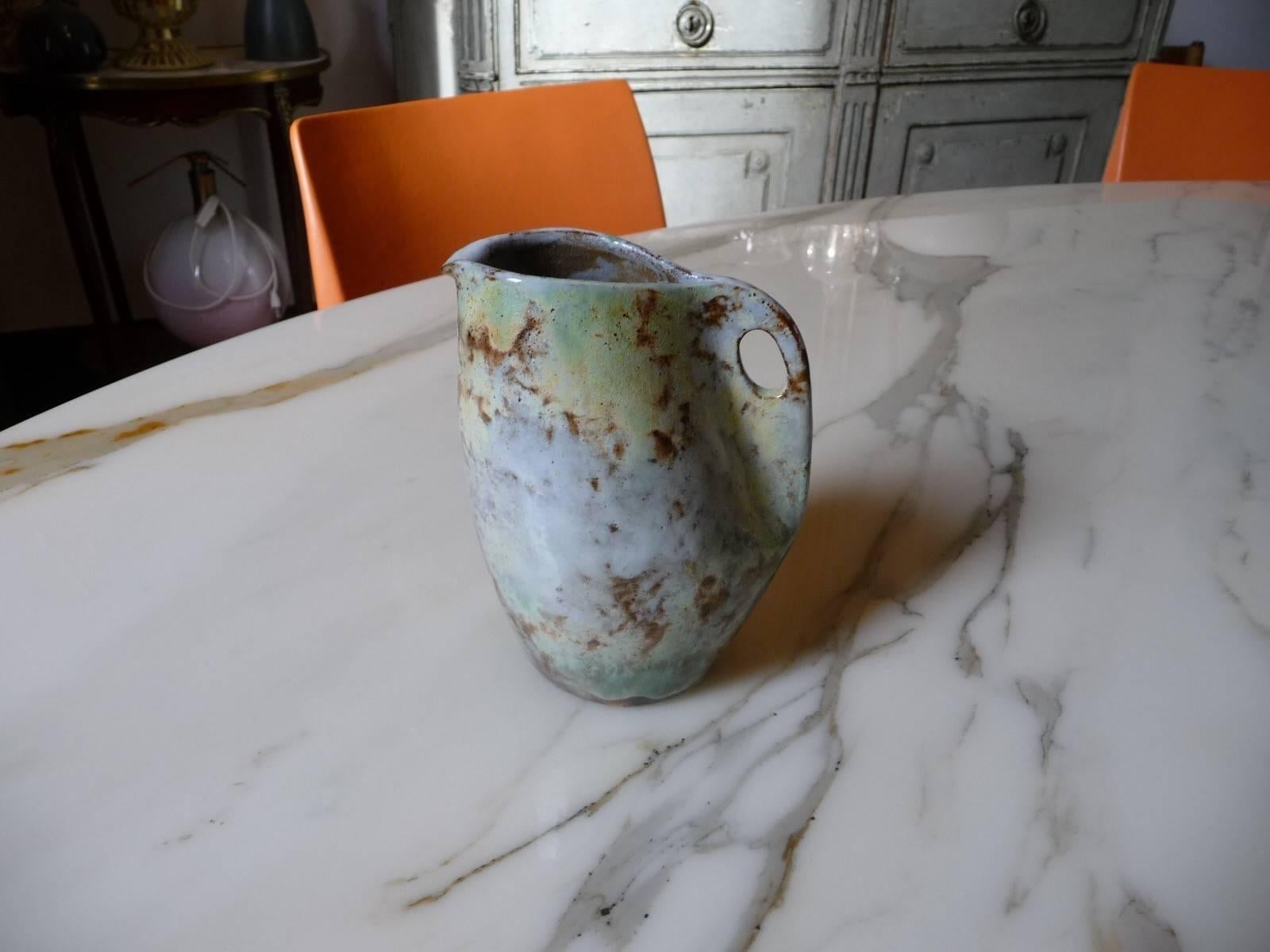 Superb sandstone pitcher. Unique piece, circa 1950, baked in a wood oven, in the Vallauris workshop. Beautiful enameling with a nice effect light and transparent. Clouded enamel blue/gray, beige on a brown background. 
Signed under the base. Height