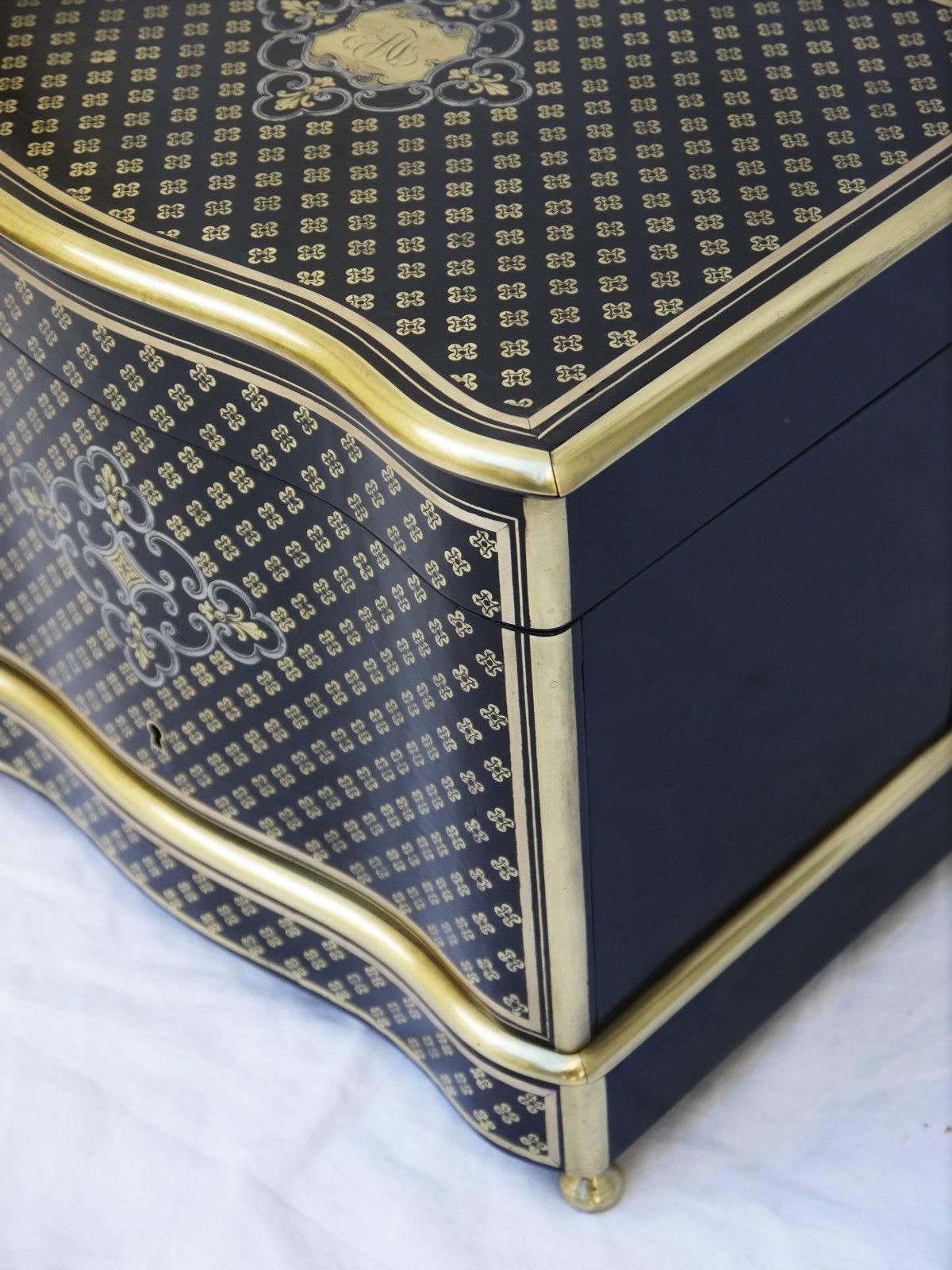 A fine antique French 19th splendid ebony plated liquor cellar box with Boulle style marquetry. Queen brass flower engraved on the lid and façade.
The cartridges are surrounded by a thin tin inlay. Polished bronze on ridges accentuating the