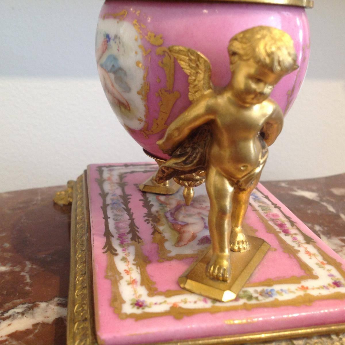 Gilt bronze and porcelain inkwell of Napoleon III period.
A porcelain terrace with a cartridge in the center representing love, surrounded by a floral border.
The porcelain plate is framed with gilded bronze and rest on four feet with claws.
The