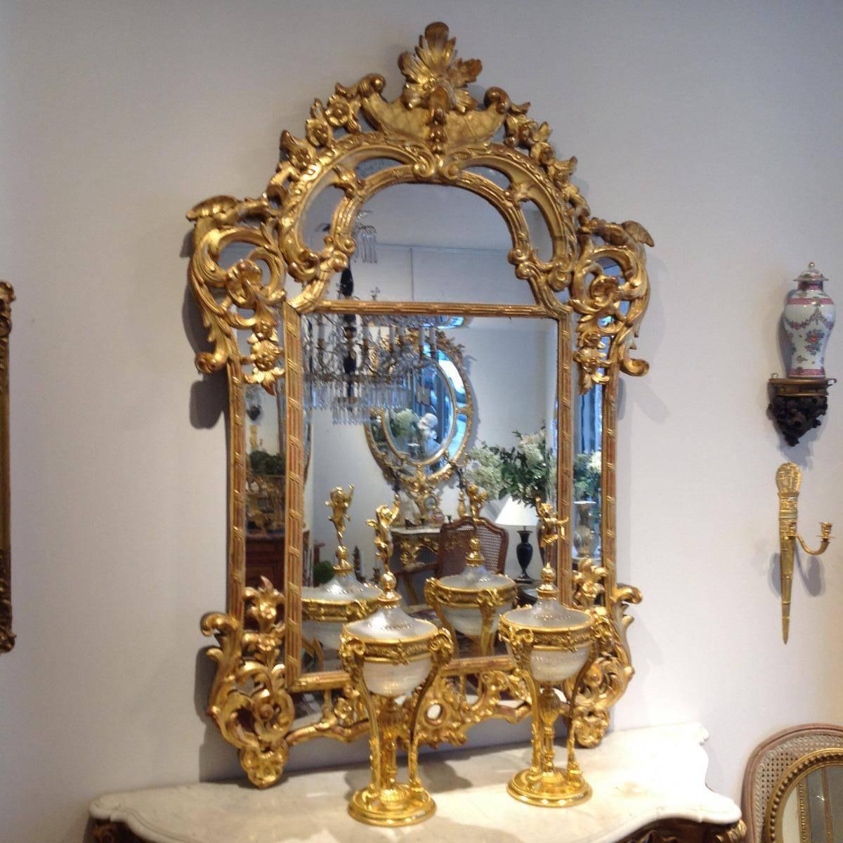 Mirror in gilded wood and mercury glass, Regency period. Decors with acanthus leaves, flowers, and shells.
Very decorative and elegant piece.
 