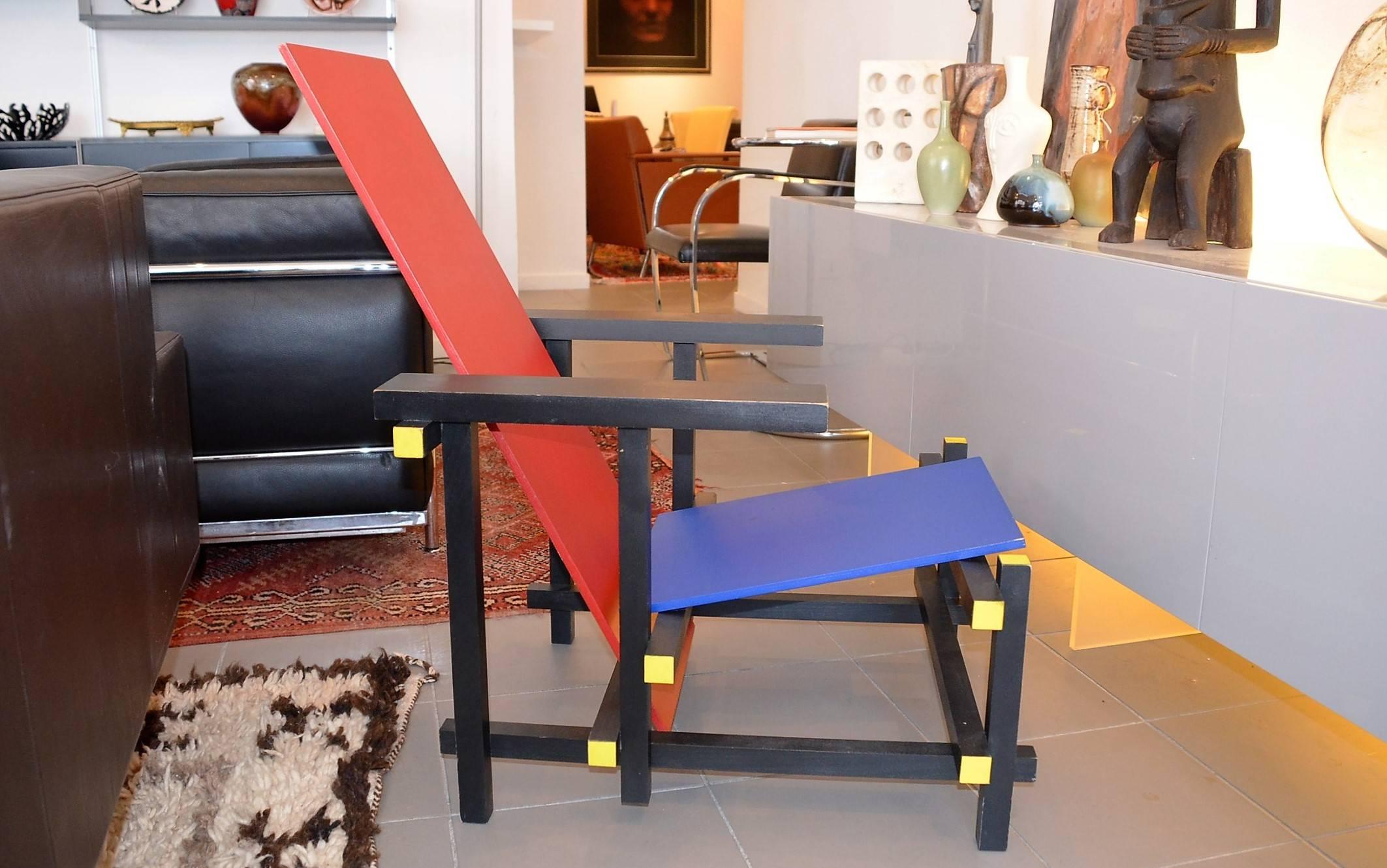 The chair has been designed in natural wood on 1918 by Gerrit Thomas Rietveld, then after meeting with the painter Piet Mondrian primary colors have been added and finally the black was added in 1923. 
Thus, its structure is colored in black, his