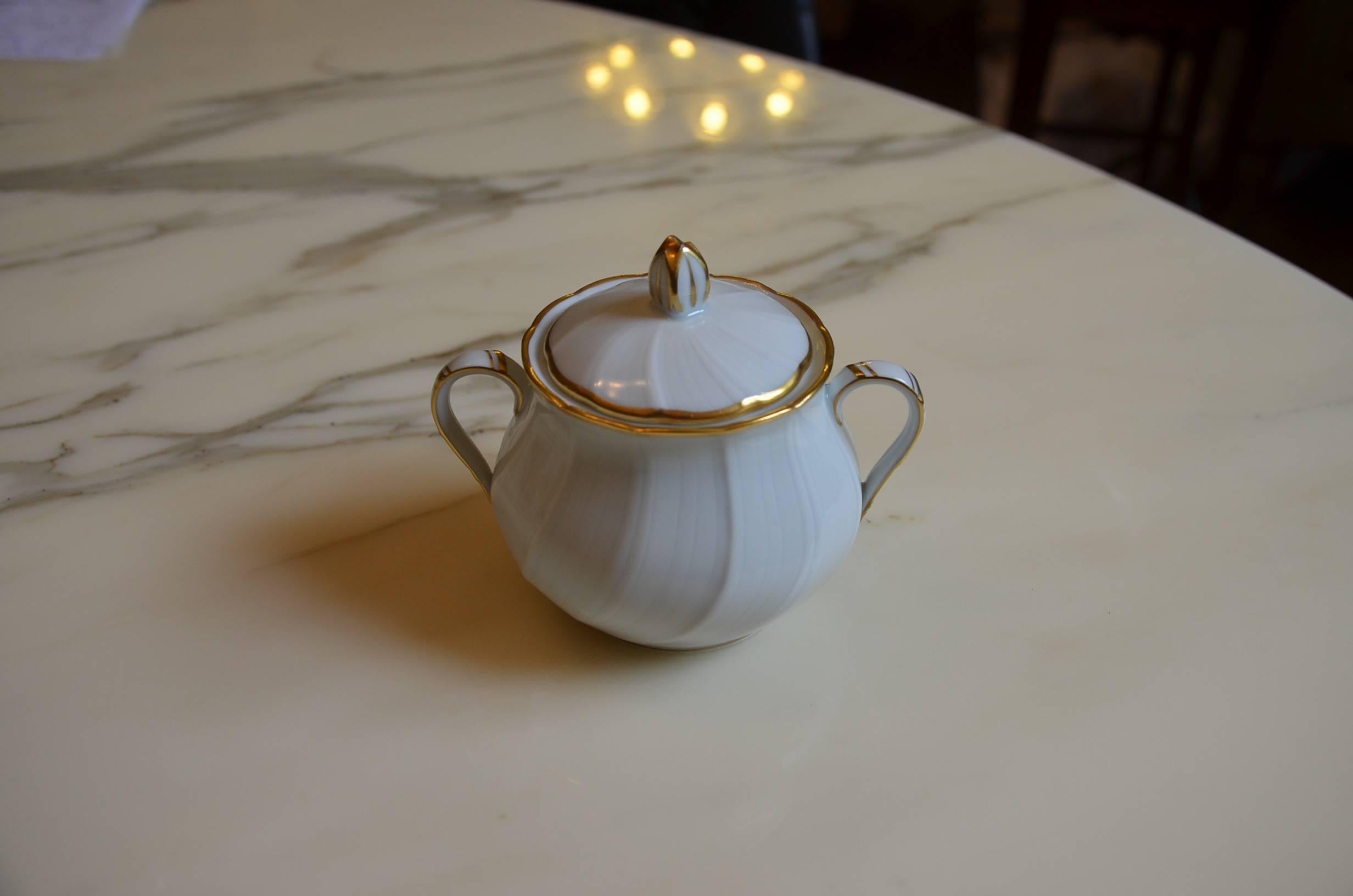 Tea service with teapot, nine cups and plates, a sugar pot and two pots for the milk by Bernardaud. This is the Verlaine model and has a brillant white porcelain with edges en fine gold.

Dimensions:

Cup: Diameter 9 cm / height 4.7 cm.

Plat: