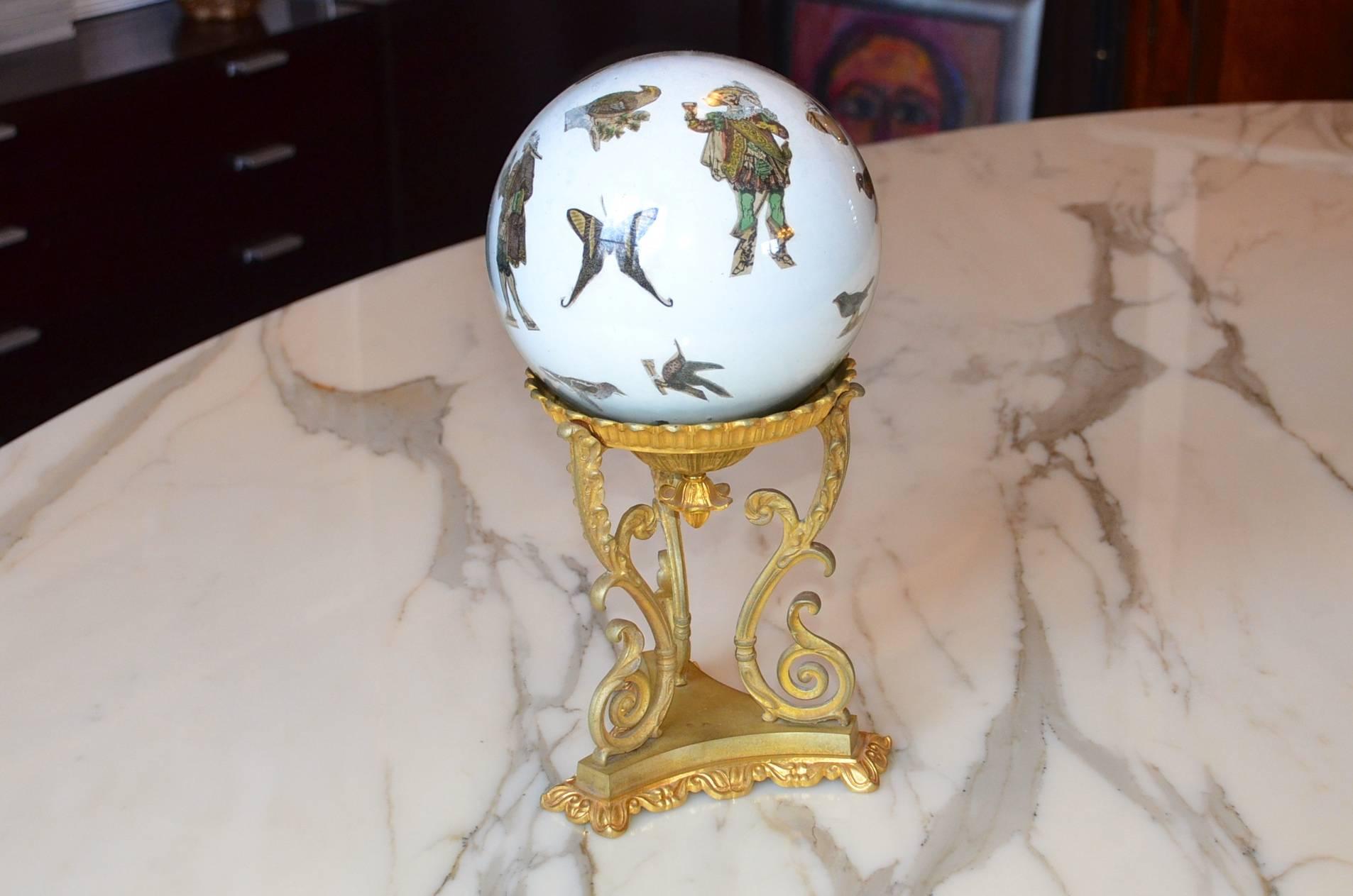 Decorative glass globe on a gilded bronze stand. The globe is finely decorated. It looks like a Murano technique although it comes from France. It rests on a beautiful gilded bronze stand with floral decoration. The usage it's a kind of mystery to