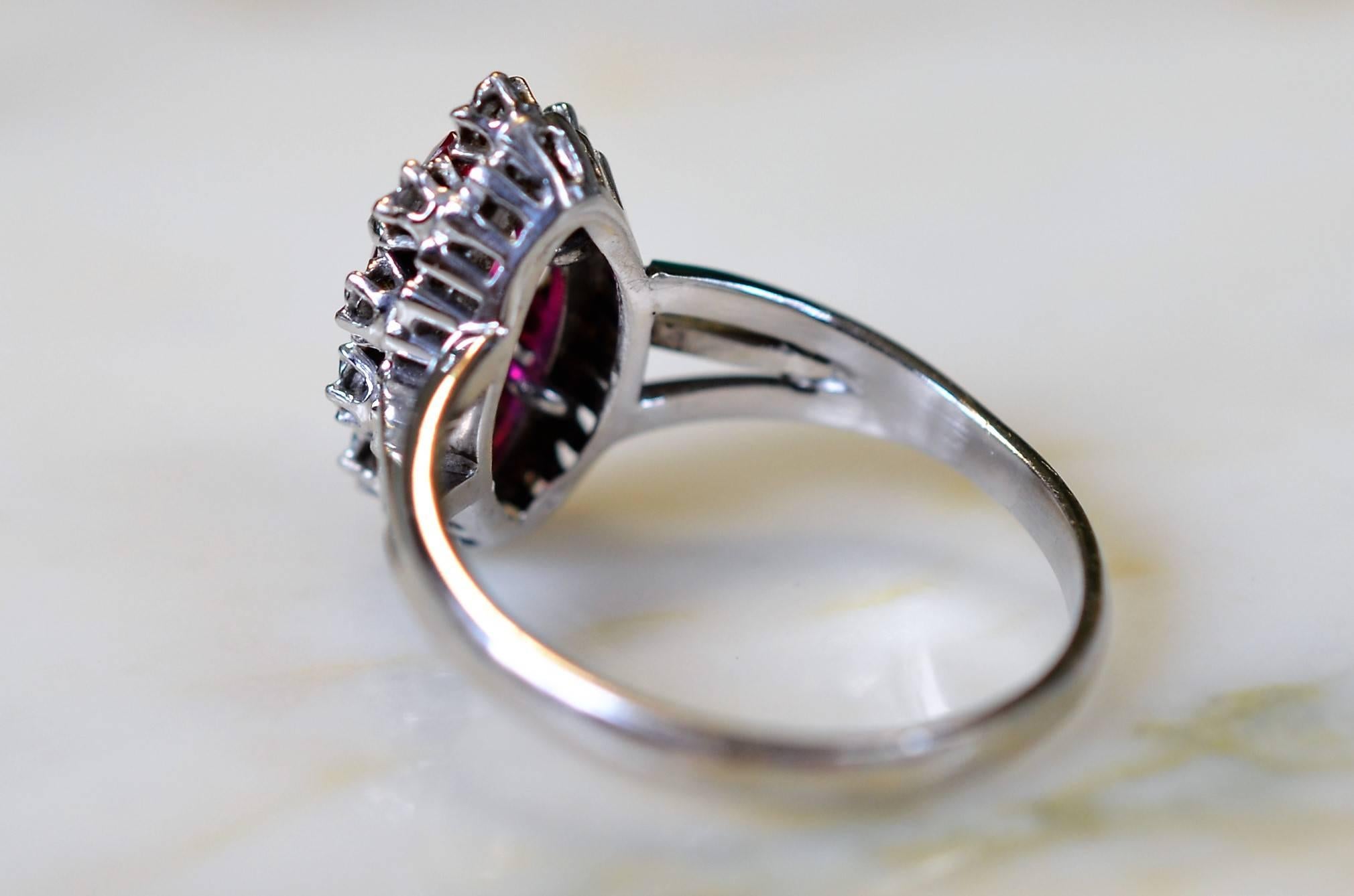 Vintage ring in 18-carat white gold (hallmarked) adorns ruby 11 x 6 mm in a circle of diamonds.

Tour finger: 61.