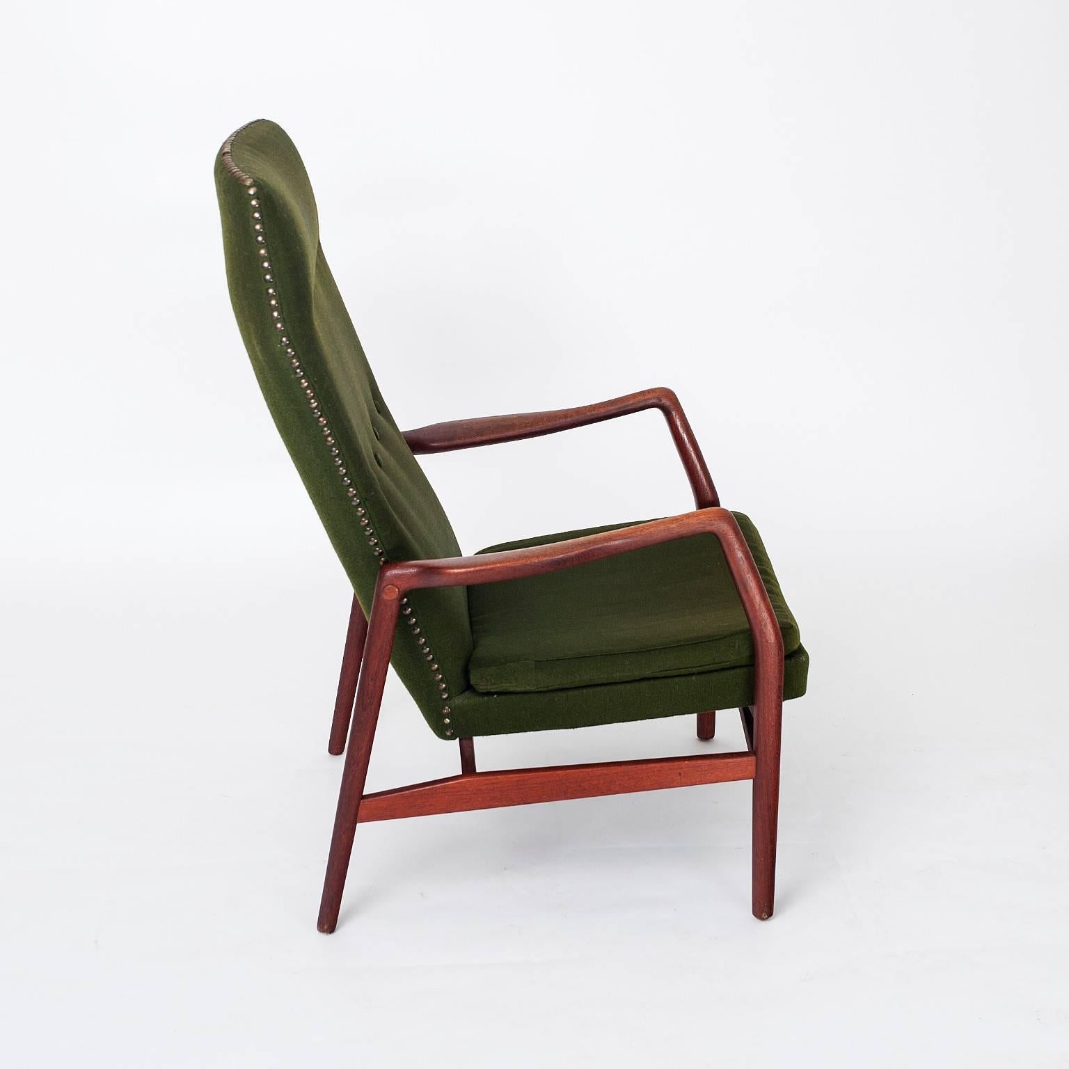 This is an original Kurt Olsen Model 215b high back lounge chair produced by Slagelse Møbelværk, Denmark. Designed in 1954 the Model 215b is made from a solid teak frame and upholstered green wool. It also features brass pins across the top edge in