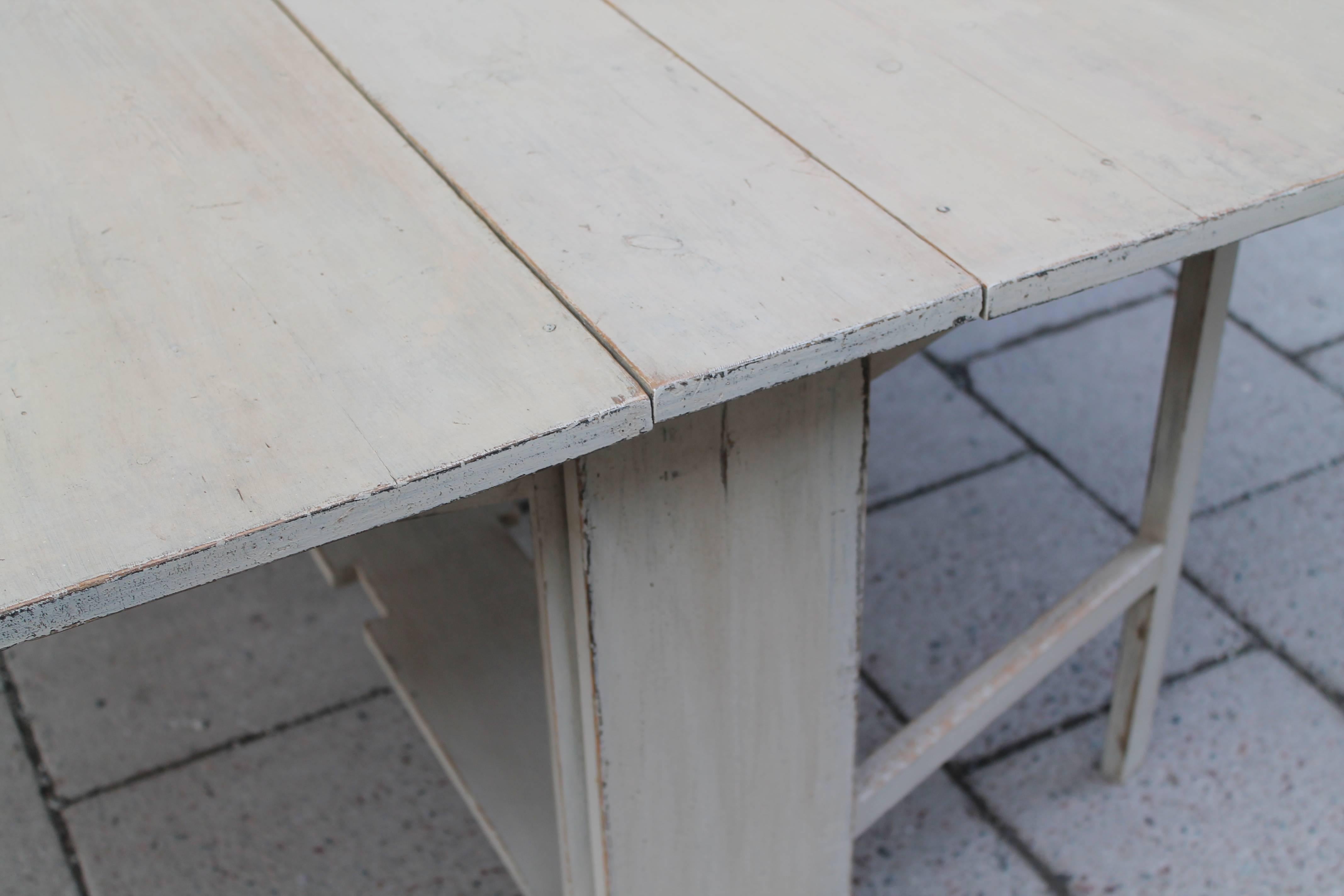 18th century Swedish drop-leaf table, gray painting, double split-leg support on each side.
 