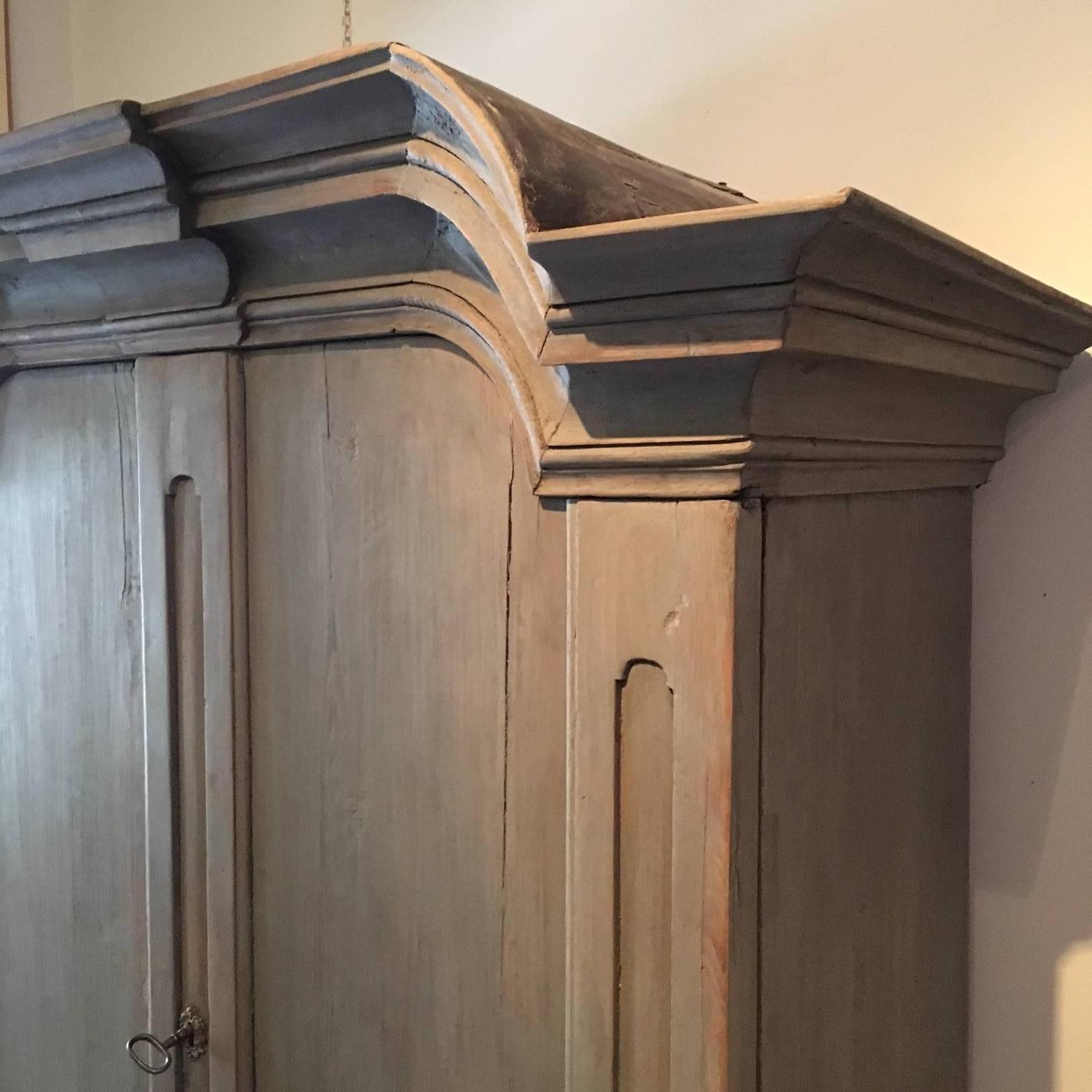 18th century Swedish Rococo cabinet. Blue or grey painting, typical Rococo top and legs. Shelfs and drawers behind doors.