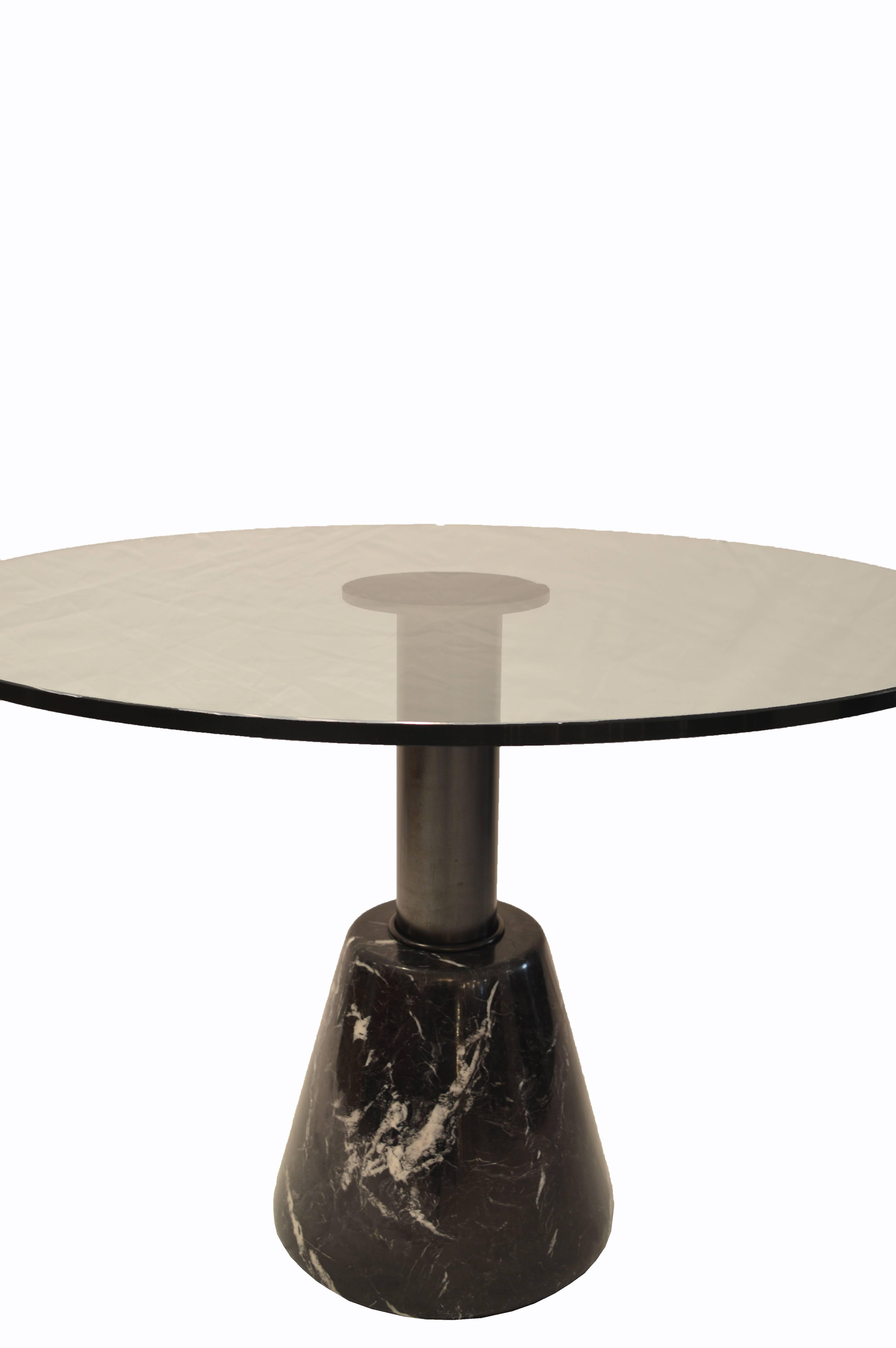 Round glass table with marble base and steel column designed by Giotto Stoppino for Acerbis International in Italy. This piece is labeled on the base. Measures: 40