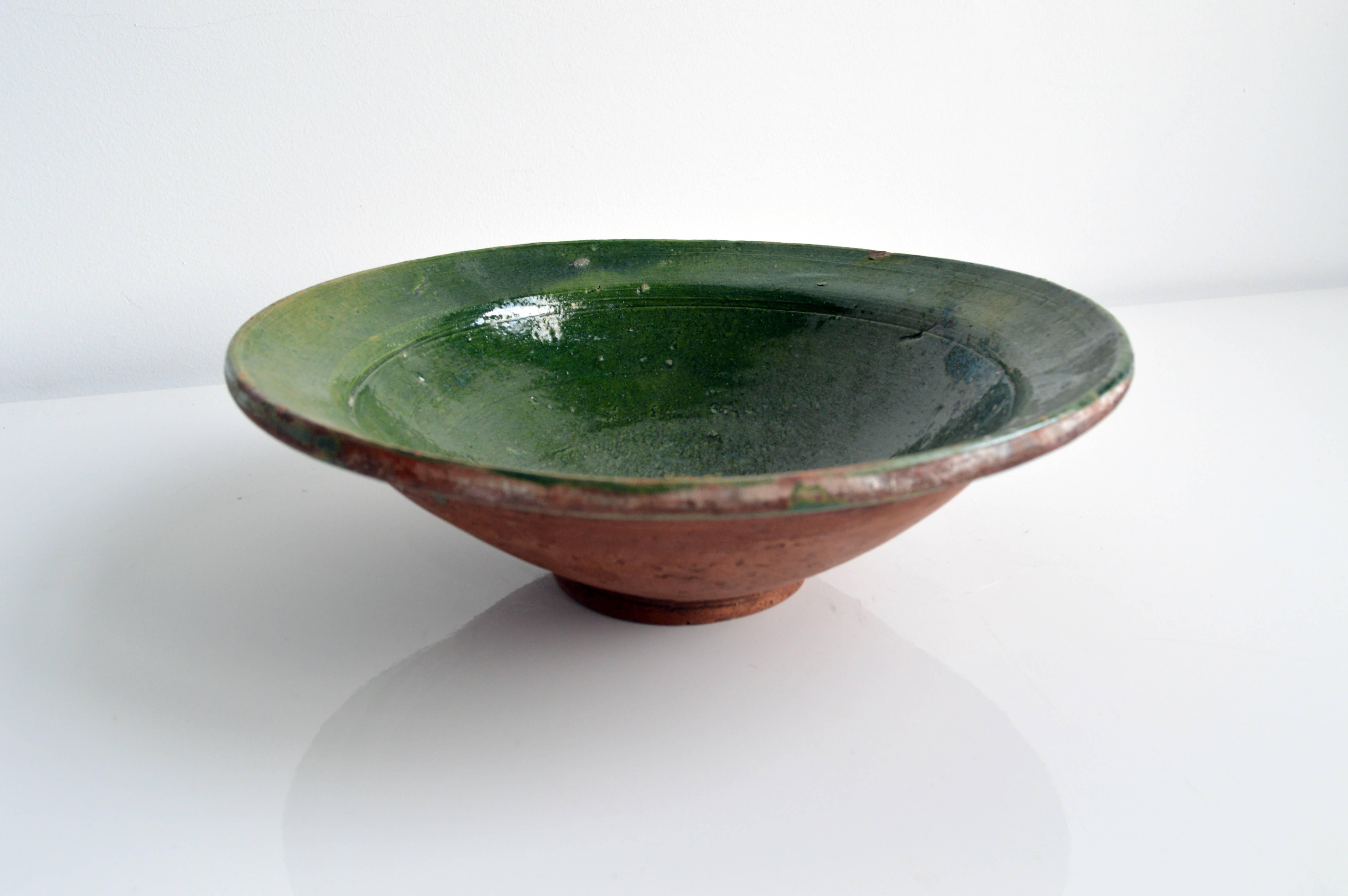 Vintage ceramic bowl with glazed green interior and natural ceramic exterior. Perfect decorative display piece, or put it to practical use as a fruit bowl.

Offered by Neal Beckstedt