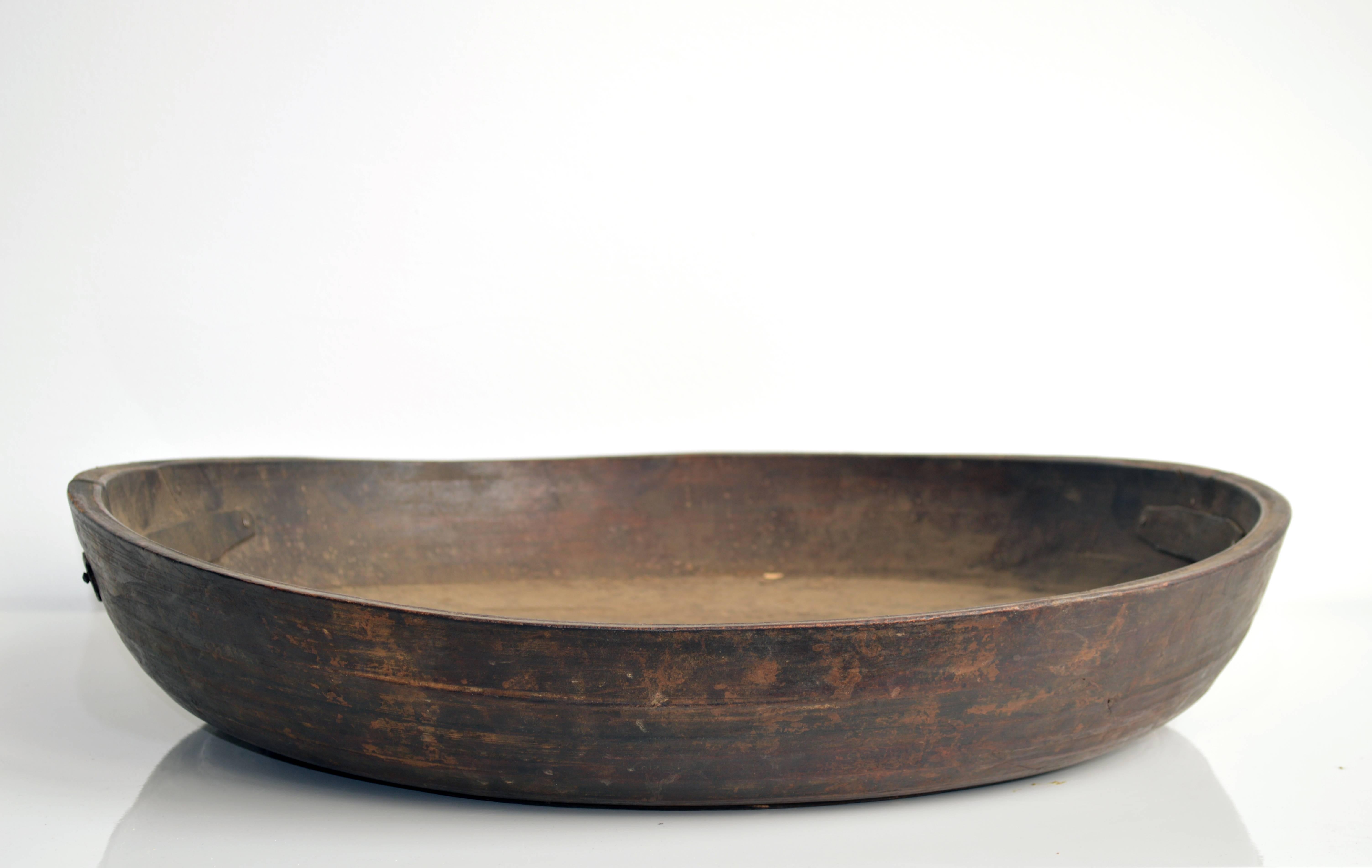 Rustic carved wood bowl, originally from Iran. This piece would make for a beautiful decorative display vessel in any home. The bowl has some cracks, secured by metal supports.

Offered by Neal Beckstedt