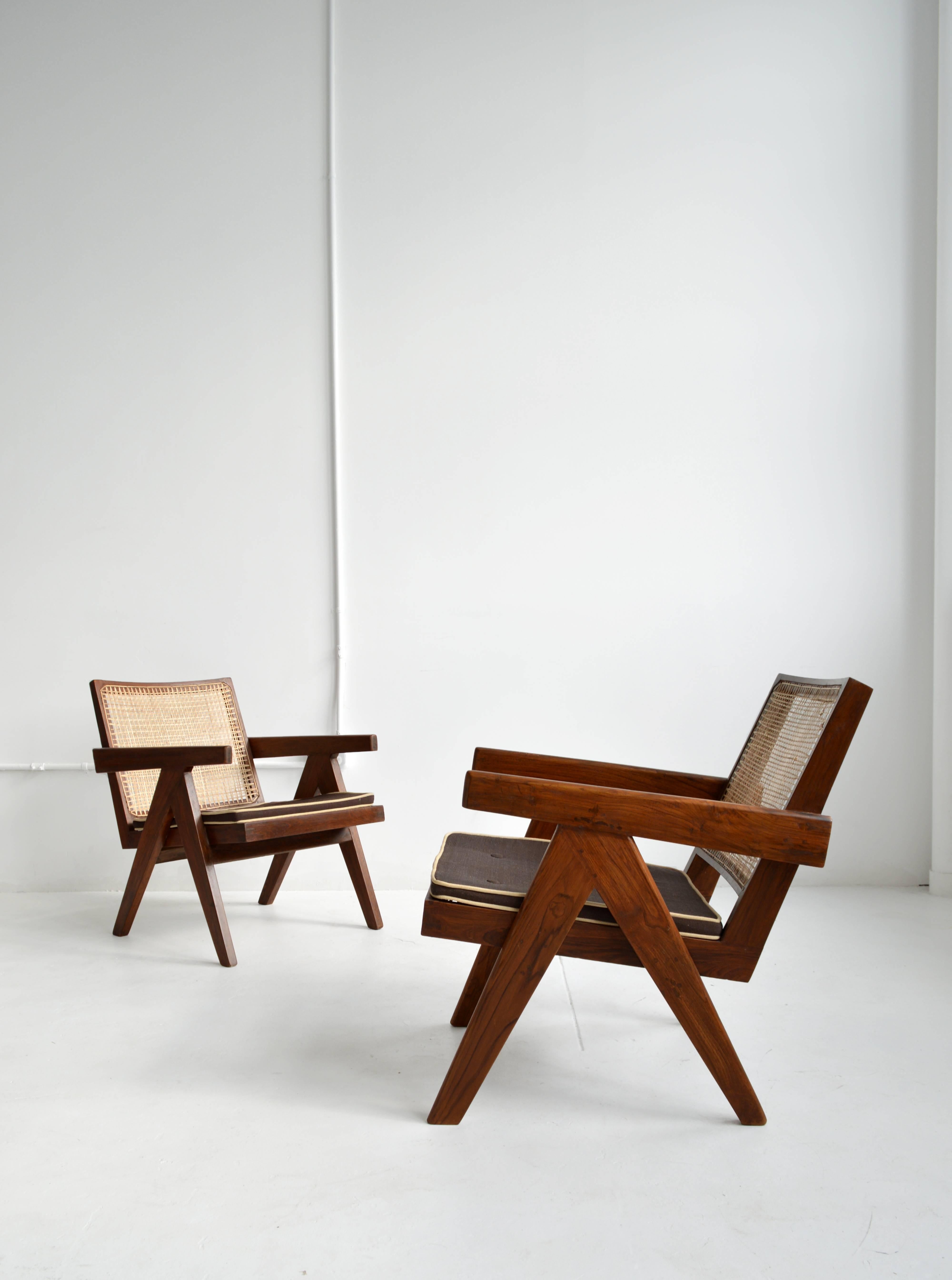Pair of iconic Pierre Jeanneret teak armchairs with cane back and seat from the Chandigarh administrative buildings in India, 1950s. Jeanneret's simplistic design highlights the inherent beauty and integrity of his materials and convey a refined,