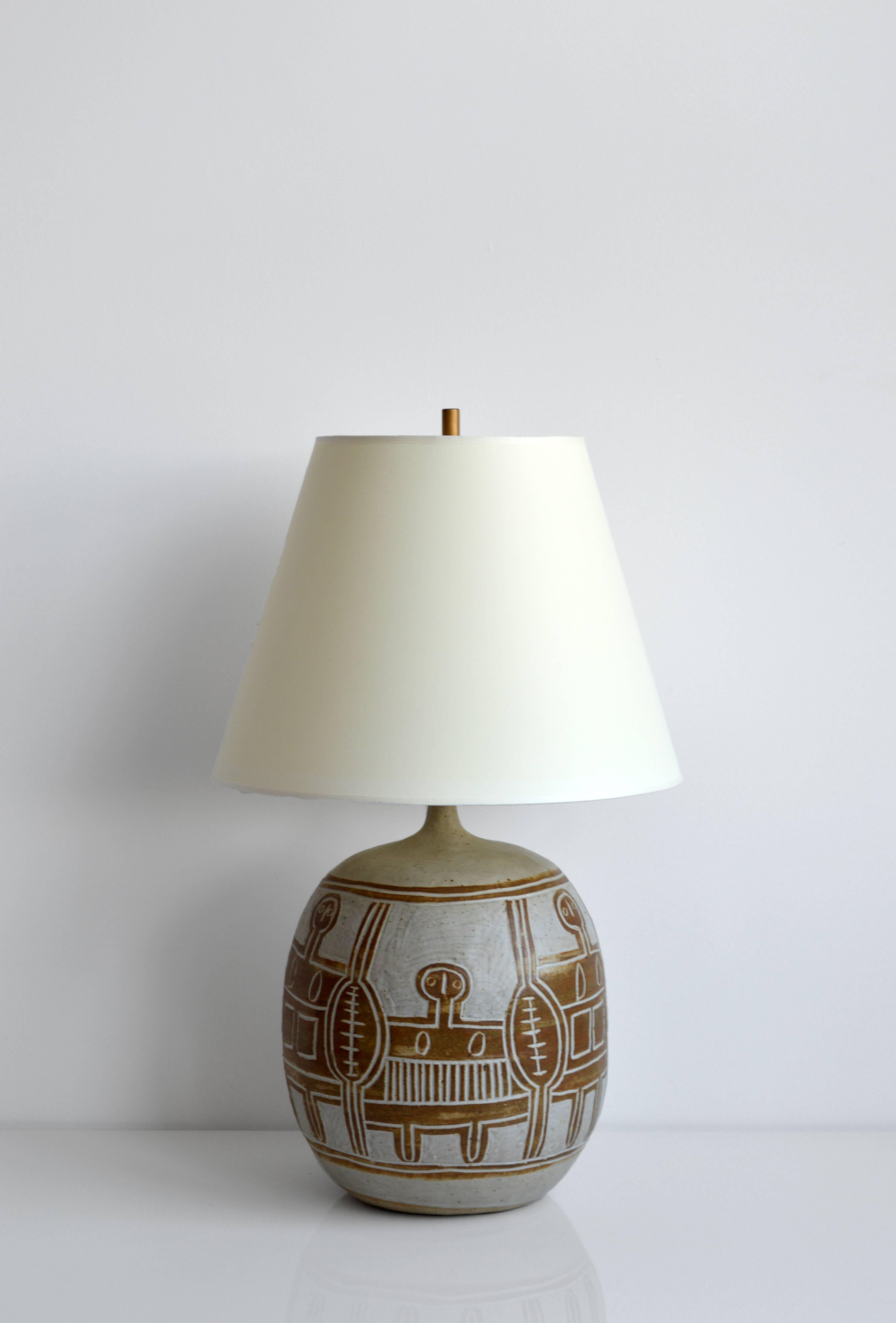 Vintage French ceramic table lamp. Carved figural artwork surrounds the base. This lamp has been rewired for US use with a brown silk cord. Wonderful for any bedside table or case piece.

New paper shade included.

Offered by Neal Beckstedt