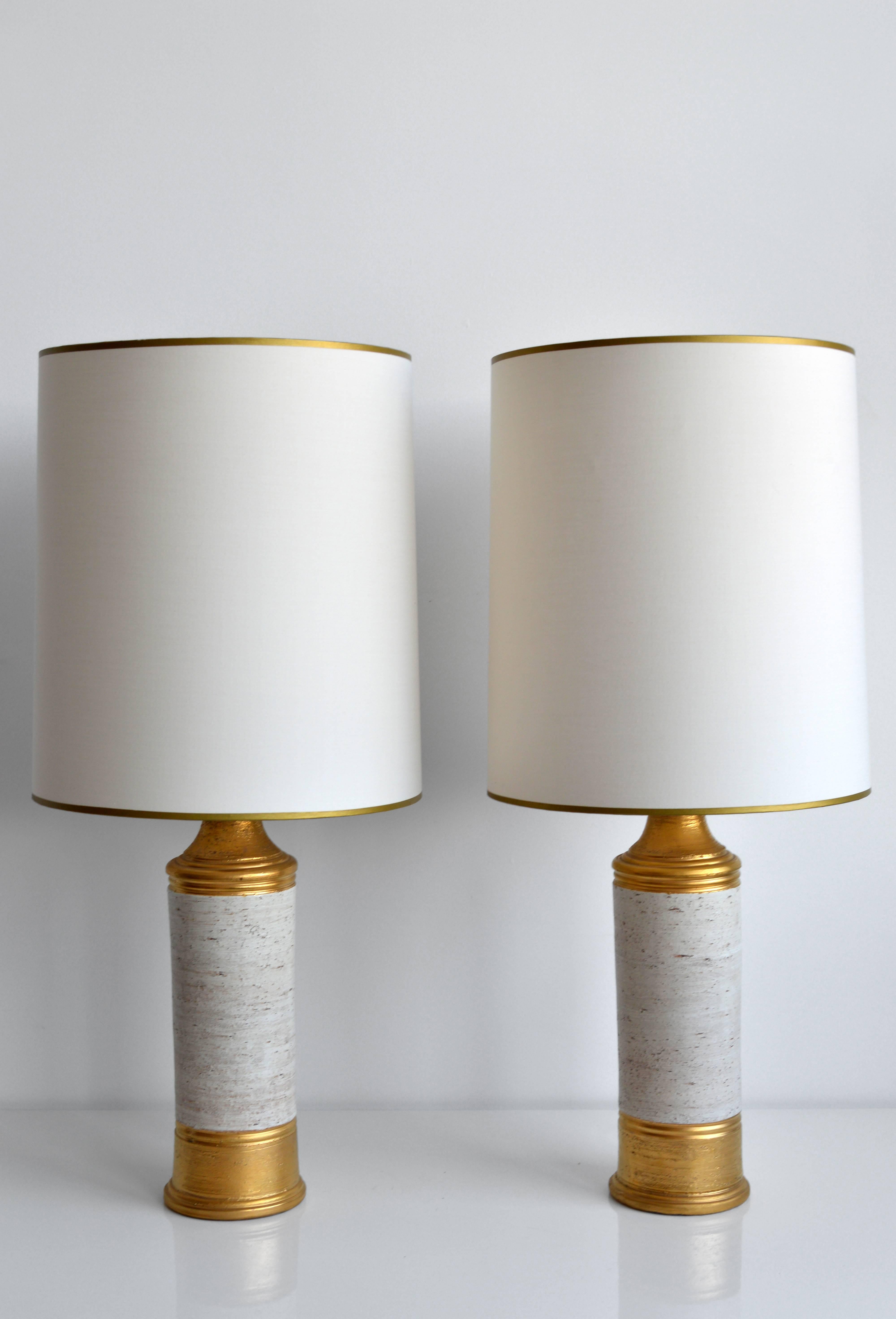 Pair of vintage table lamps by Italian ceramics company Bitossi for Bergboms, circa 1960s. Each lamp has a matte gold finish with an off-white 