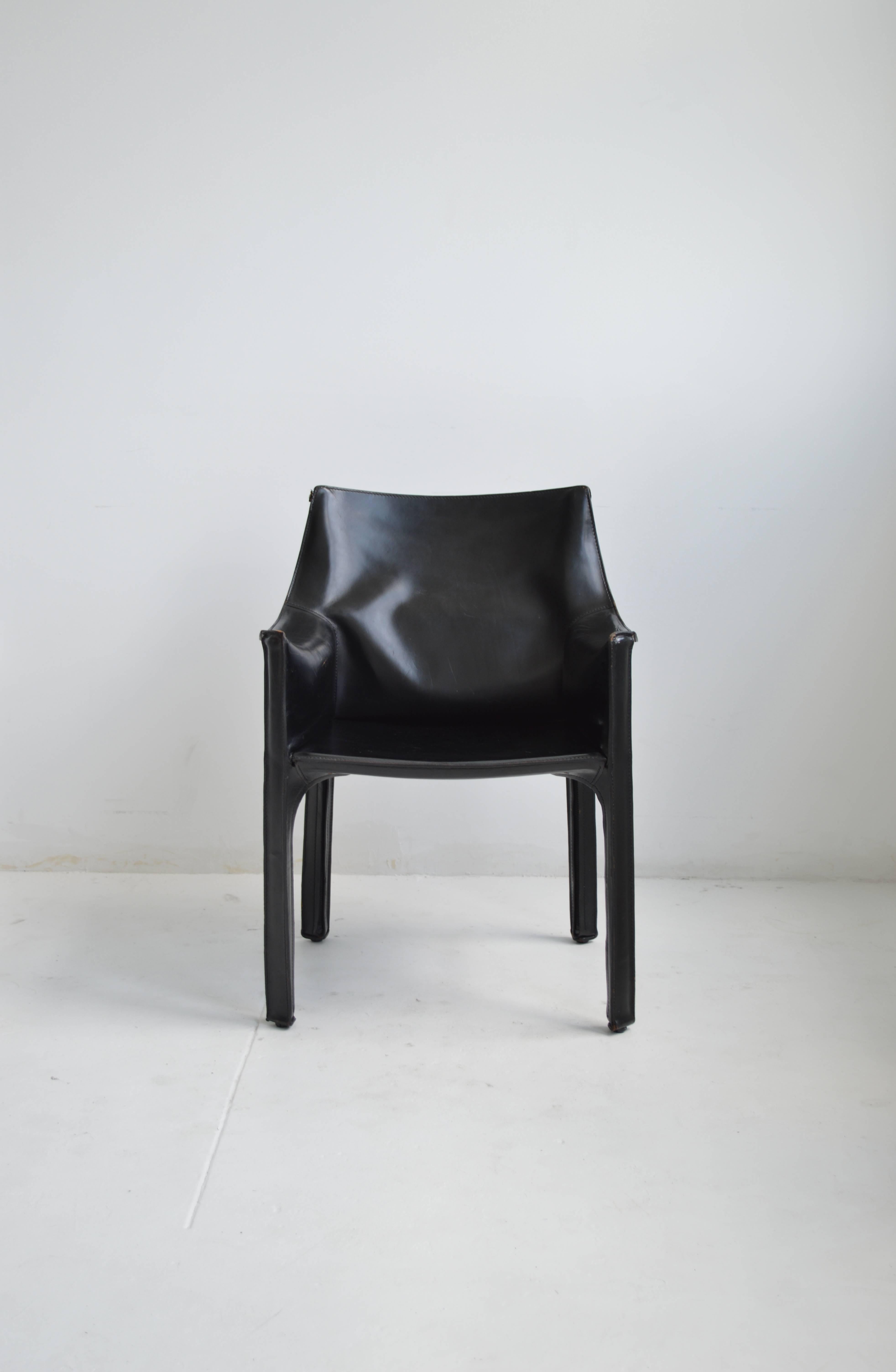 Mario Bellini 'Cab' chair for Italian manufacturer Cassina in the 1970's. This chair features a black saddle leather over a steel frame. Four zippers run beneath the chair's legs. There is some visible wear along the seams creating a lovely patina