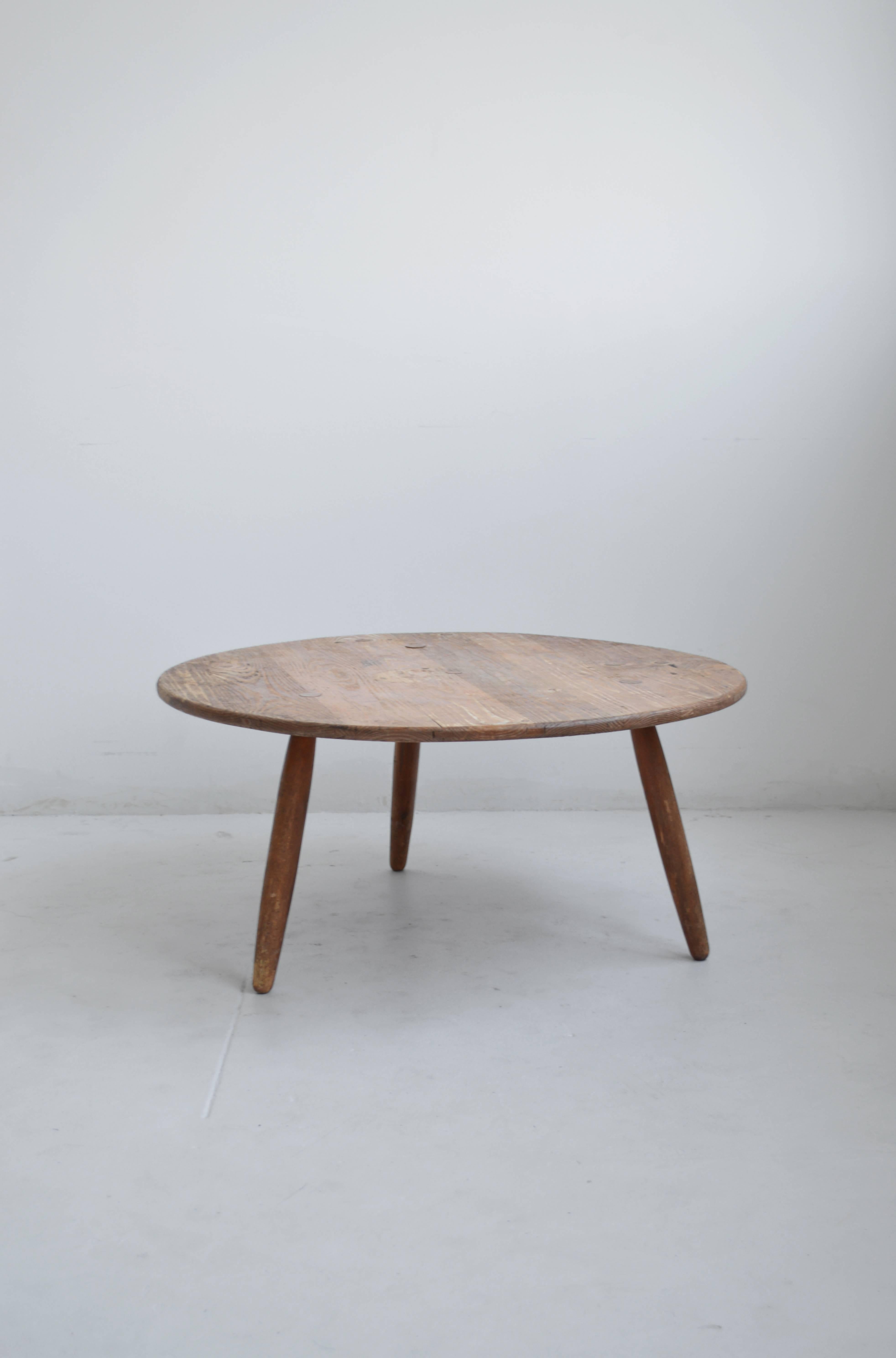 Beautiful Mid-Century coffee table attributed to the iconic French designer Charlotte Perriand. In good vintage condition, this charming coffee or cocktail table features three solid wood legs and a round top with a lovely patina and visible wear.