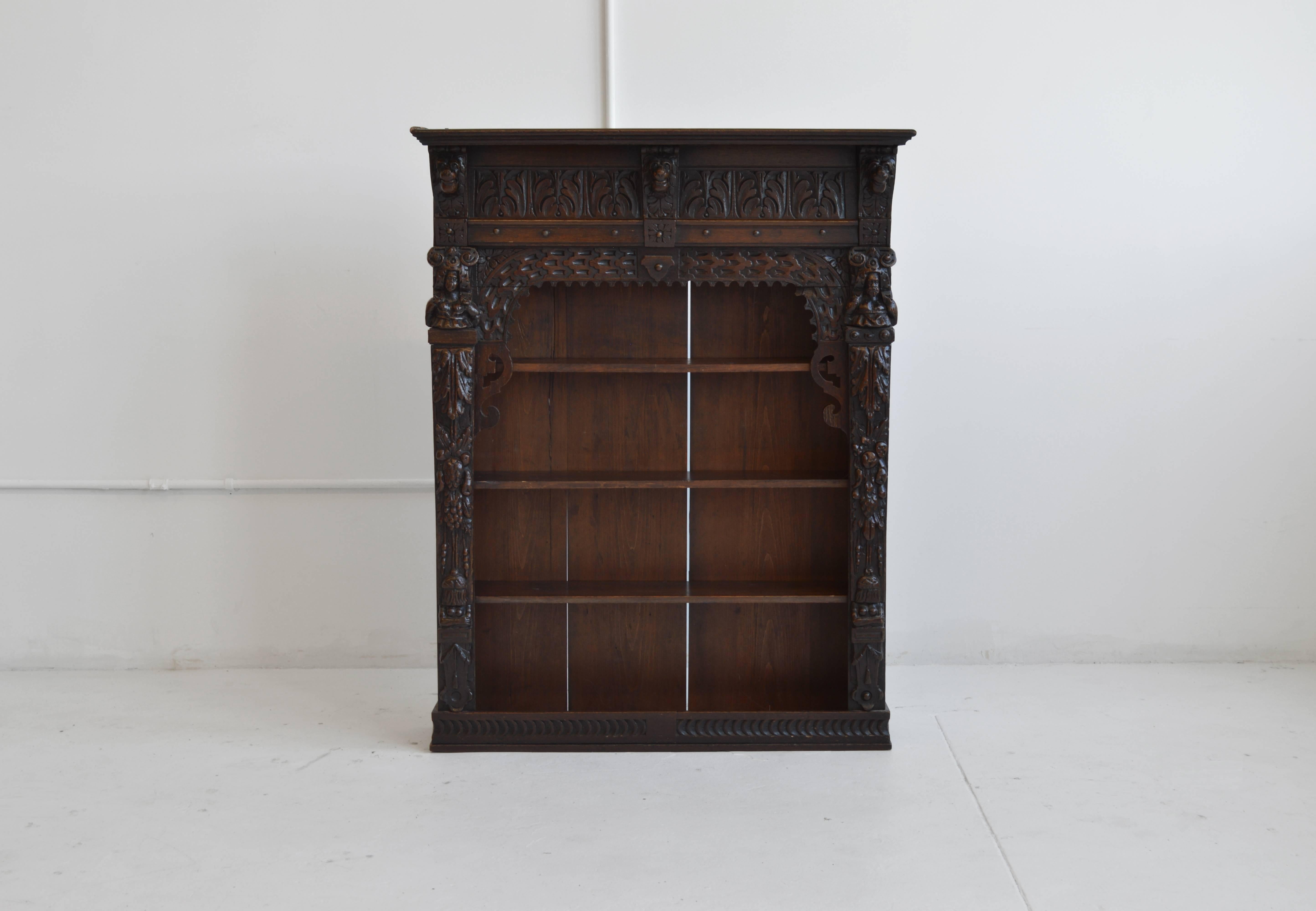19th century Victorian antique oak carved wall cabinet originally from England. This handsome piece features ornate carvings in a deep, mahogany finish. Three lions are carved at the top among acanthus leaves along the top panel and a human bust at