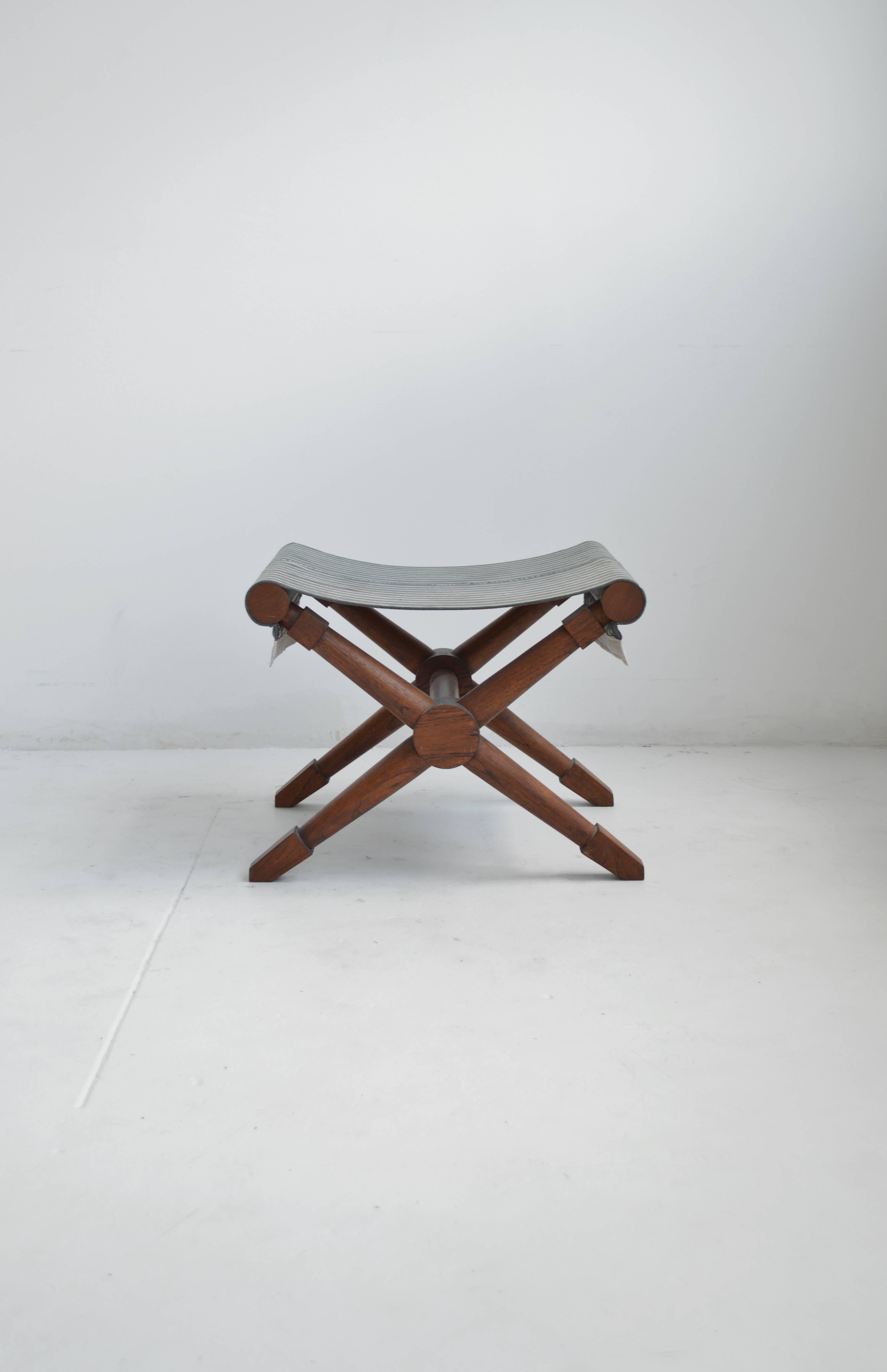 Vintage x-style stool in the style of Jean Michel Frank in the designer's signature French modern neoclassical style. This stool has recently been recovered in a vintage indigo striped French linen with a flat silk flange trim detail. The stool has