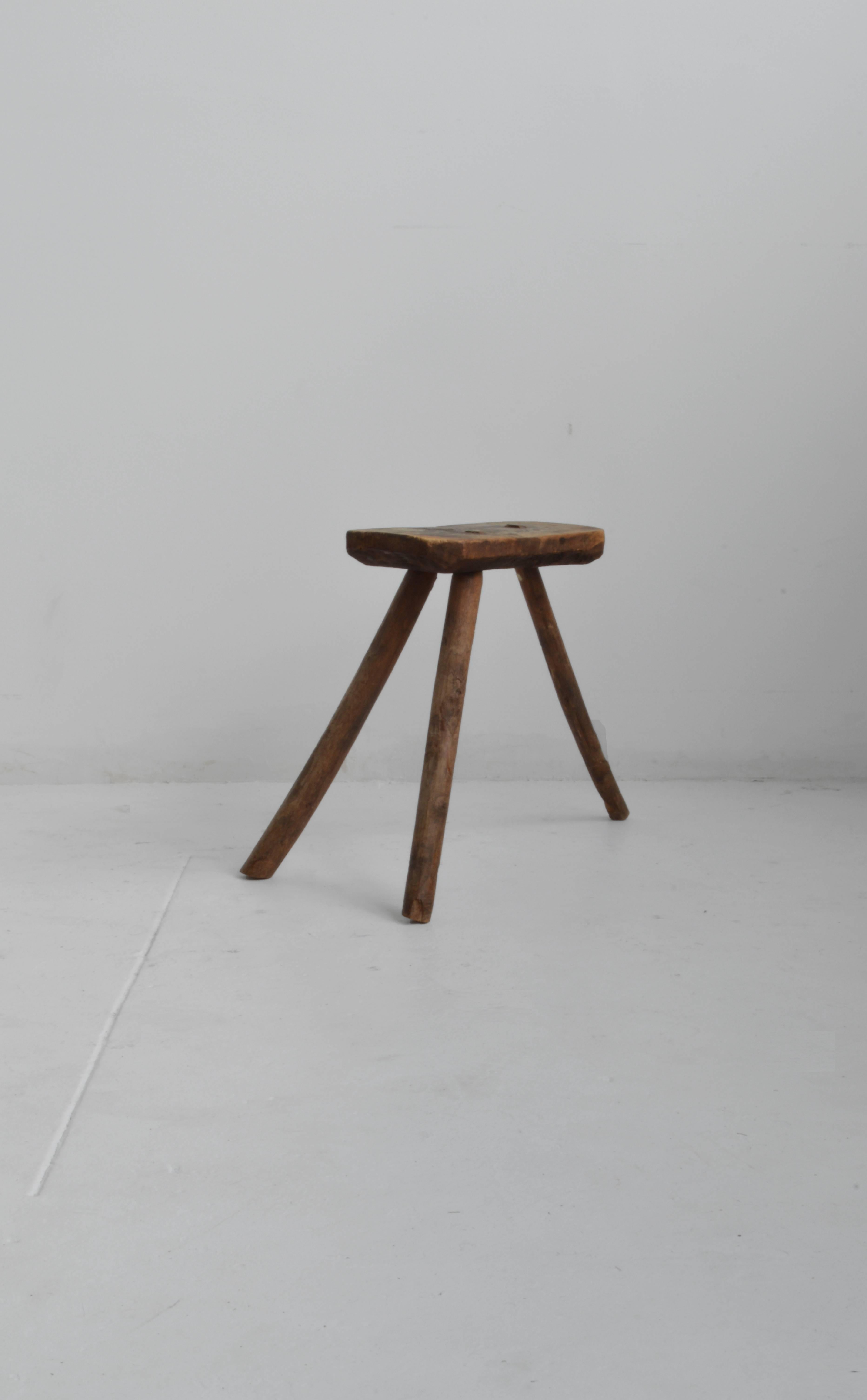 Charming late 18th century wooden milking stool. This solid wood stool has three splayed legs with a lovely patina and visible wear. Could be used as a decorative object or side table.

 