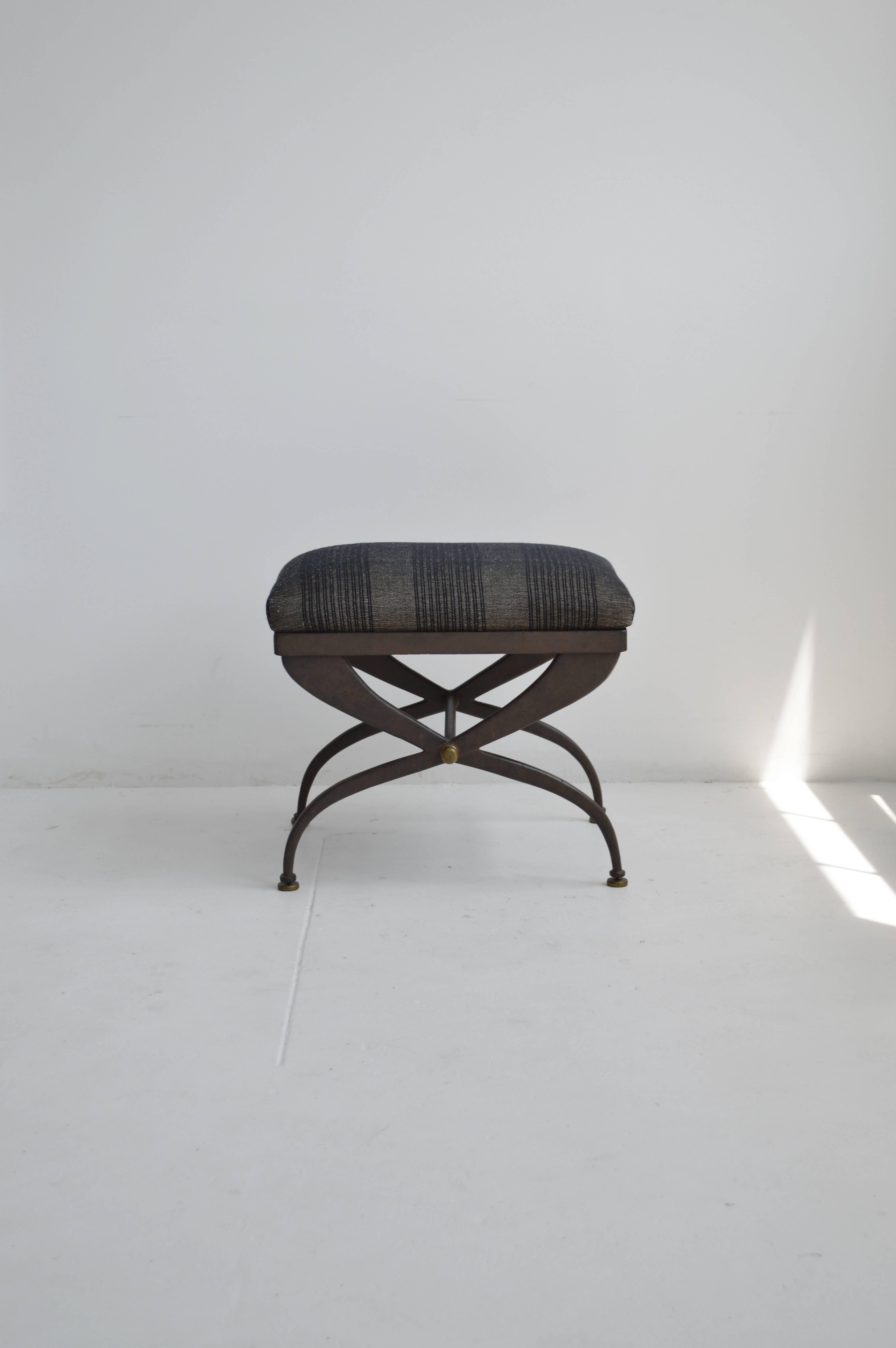 Cast iron bench originally from France in the 1940s. Recently reupholstered in a grey and black striped, handwoven fabric. The Directoire style stool features an X-shaped base and has brass detail at the joinery and feet.