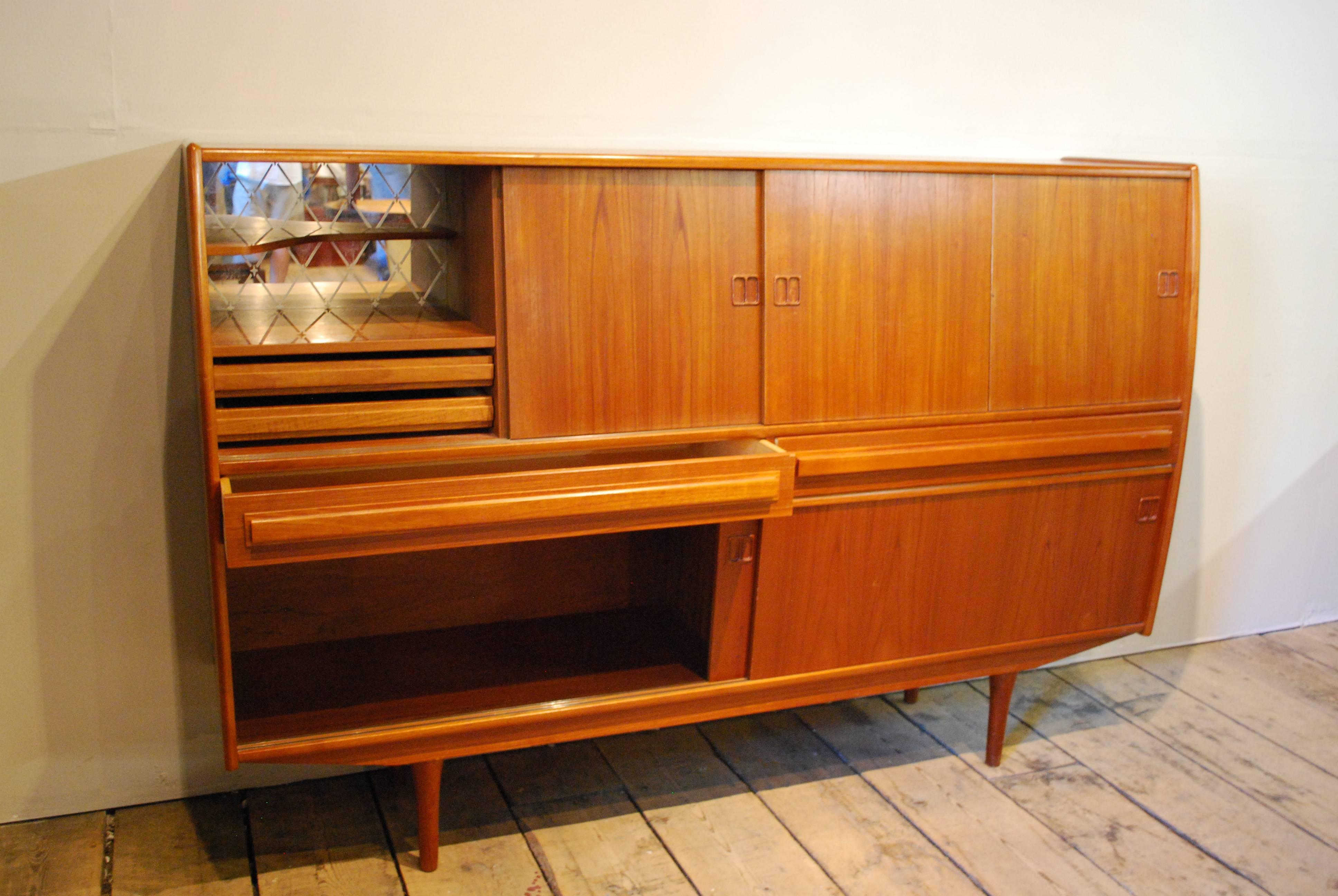 Danish Modern teak credenza designed by Jens AErthoj Jensen and Tage Molholm who opened BoConcepts in 1952.  It features six doors, quality construction throughout and fabulous storage options including adjustable shelving, felt lined dovetailed