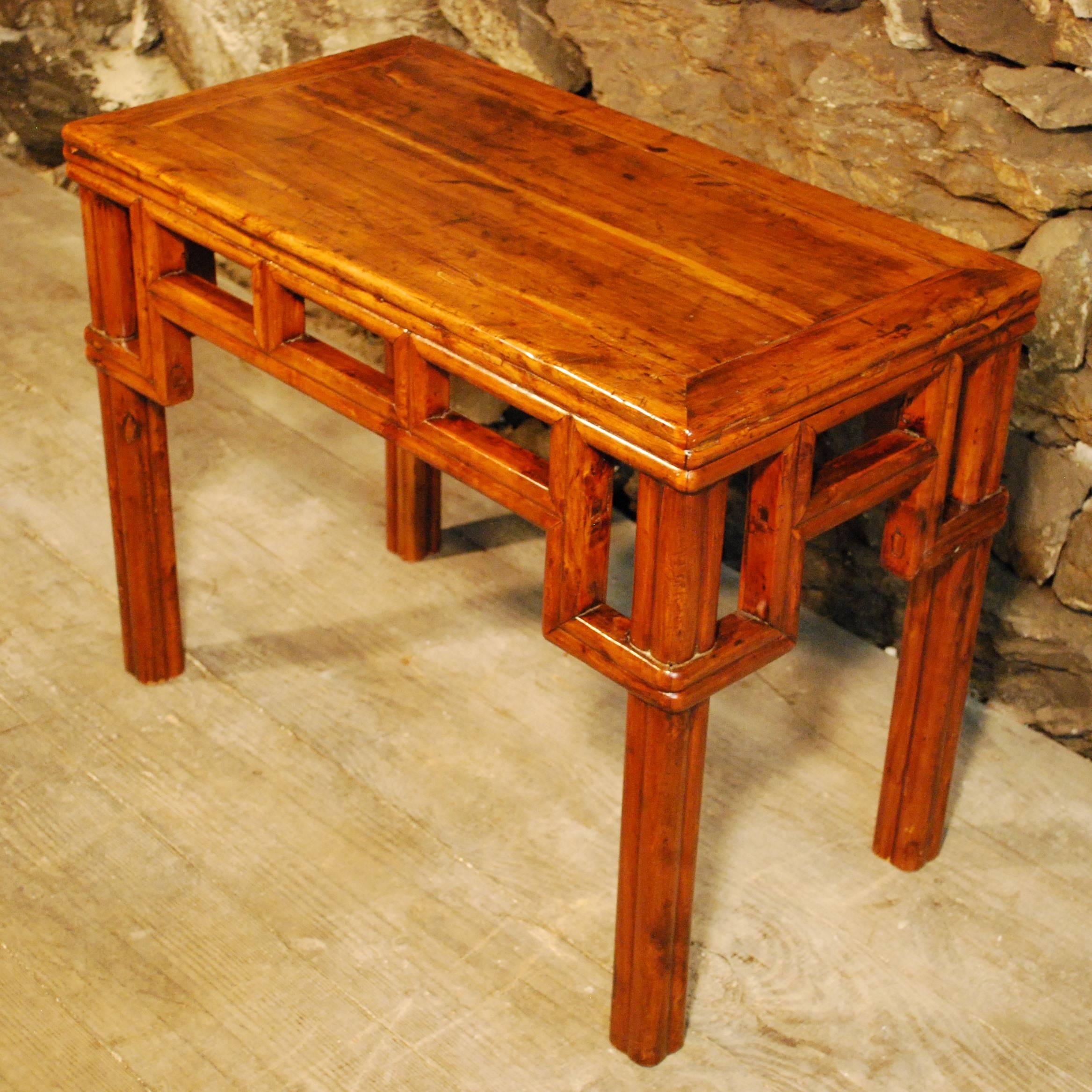 An antique Chinese faux bamboo kang table from Jiangsu province beautifully handcrafted in peach wood with clear lacquer finish and displaying a framed panel top and finely executed faux bamboo joinery. The wrapped corner detail is of special note.