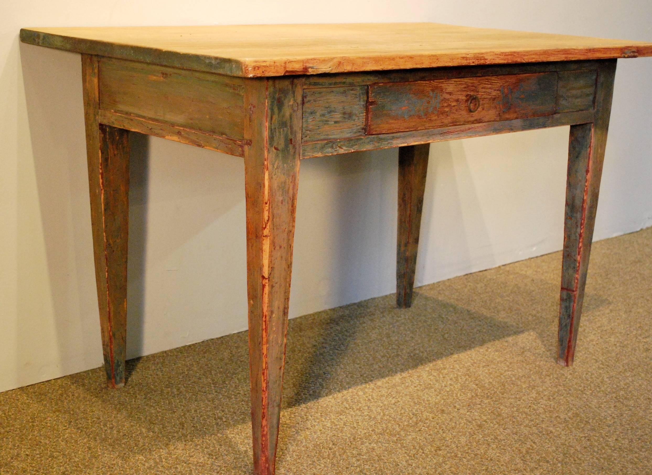 An antique Swedish writing table with one drawer, tapered legs, and hand scrapped to reveal the remnants of the original paintwork. The top has not been sanded and retains the desirable time worn ridges. George Nakashima called it 