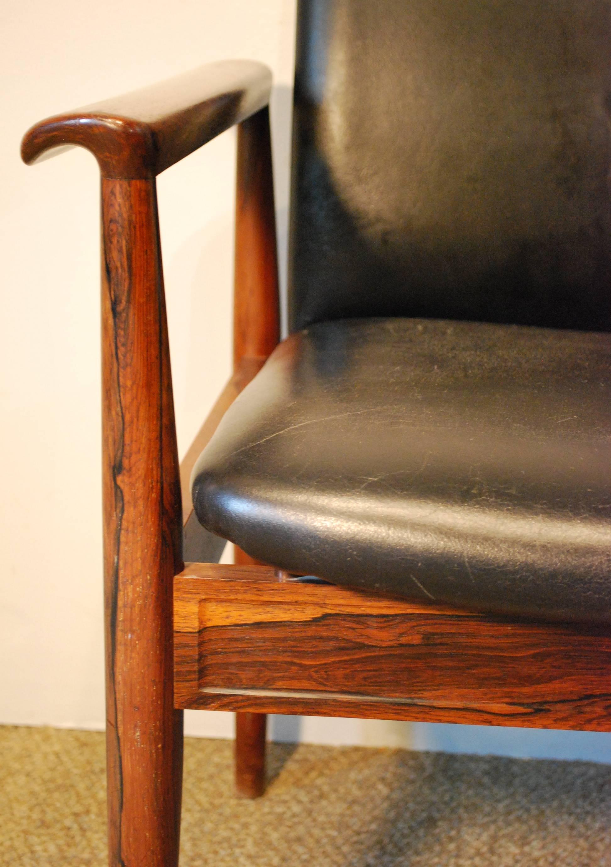 An exceptional Finn Juhl designed for France & Daverkosen 'Diplomat' chair displaying the original black leather seat and backrest in a glowing rosewood frame with beautiful detailing and joinery.