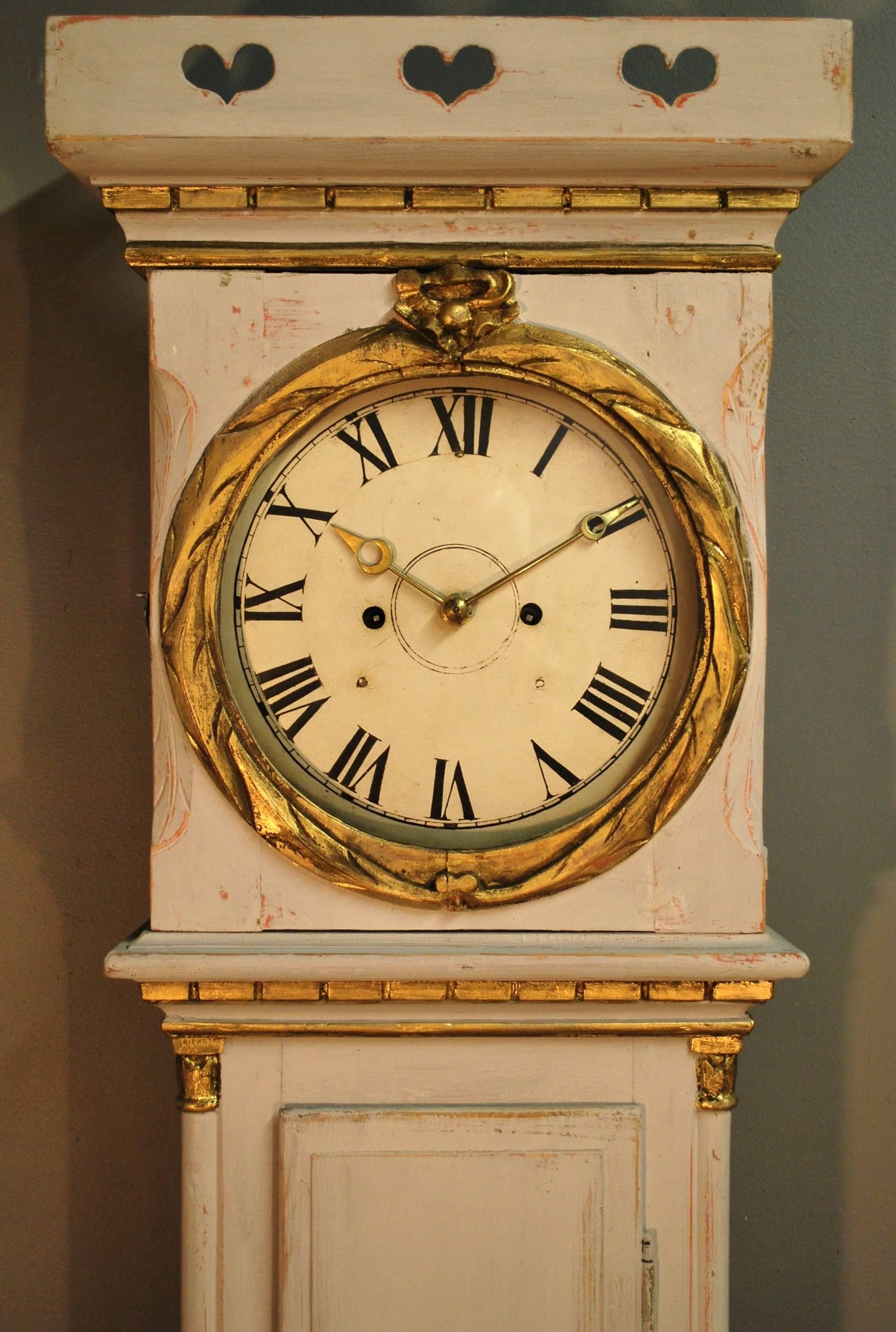An antique Danish Bornholm tall case clock displaying a decorative crown, Classic dentil trim, a swagged detail on the base. The original brass weight driven and pendulum regulated works have been cleaned and in excellent running order, chiming on