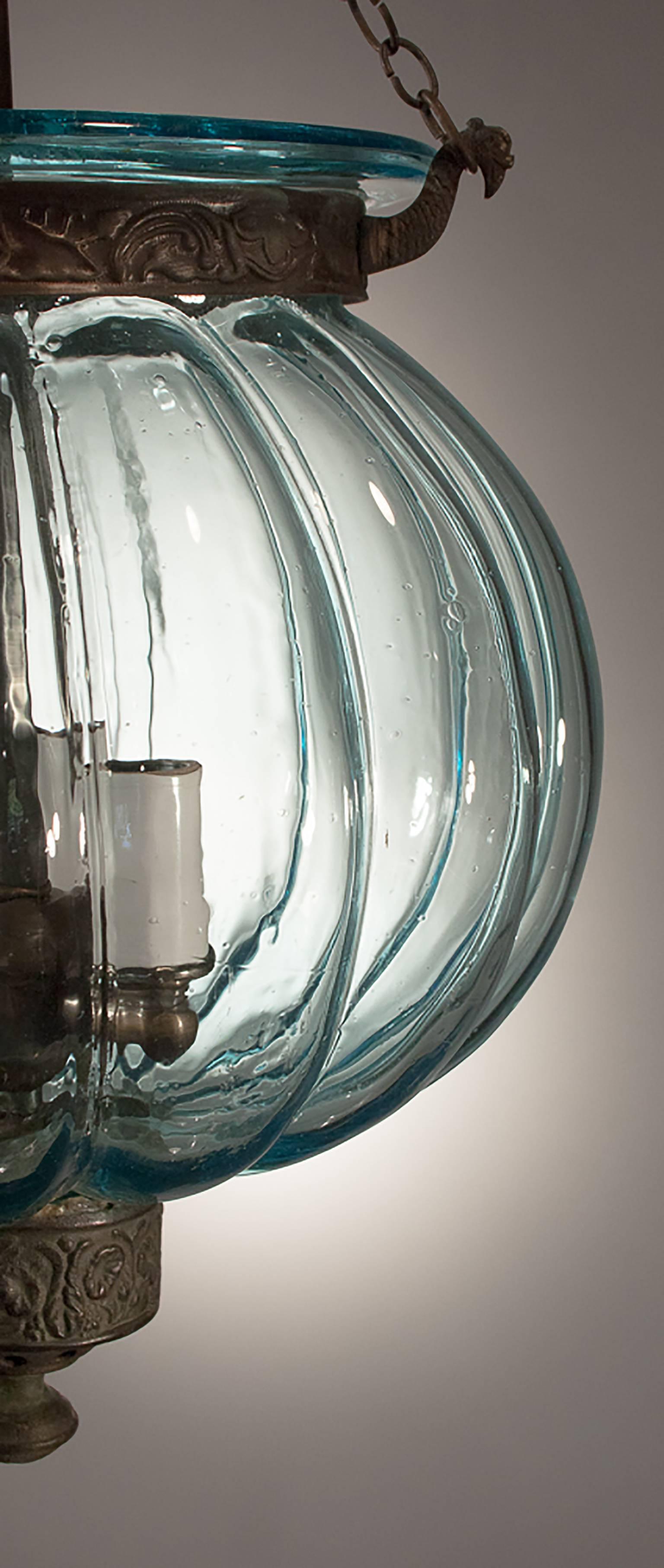 Hand blown in Belgium, circa 1860, the aqua tint of this melon bell jar reflects a warm light. The lantern has its original decorative smoke bell and embossed brass details, including a slightly askew finial. An acid-etched indicia on the glass says