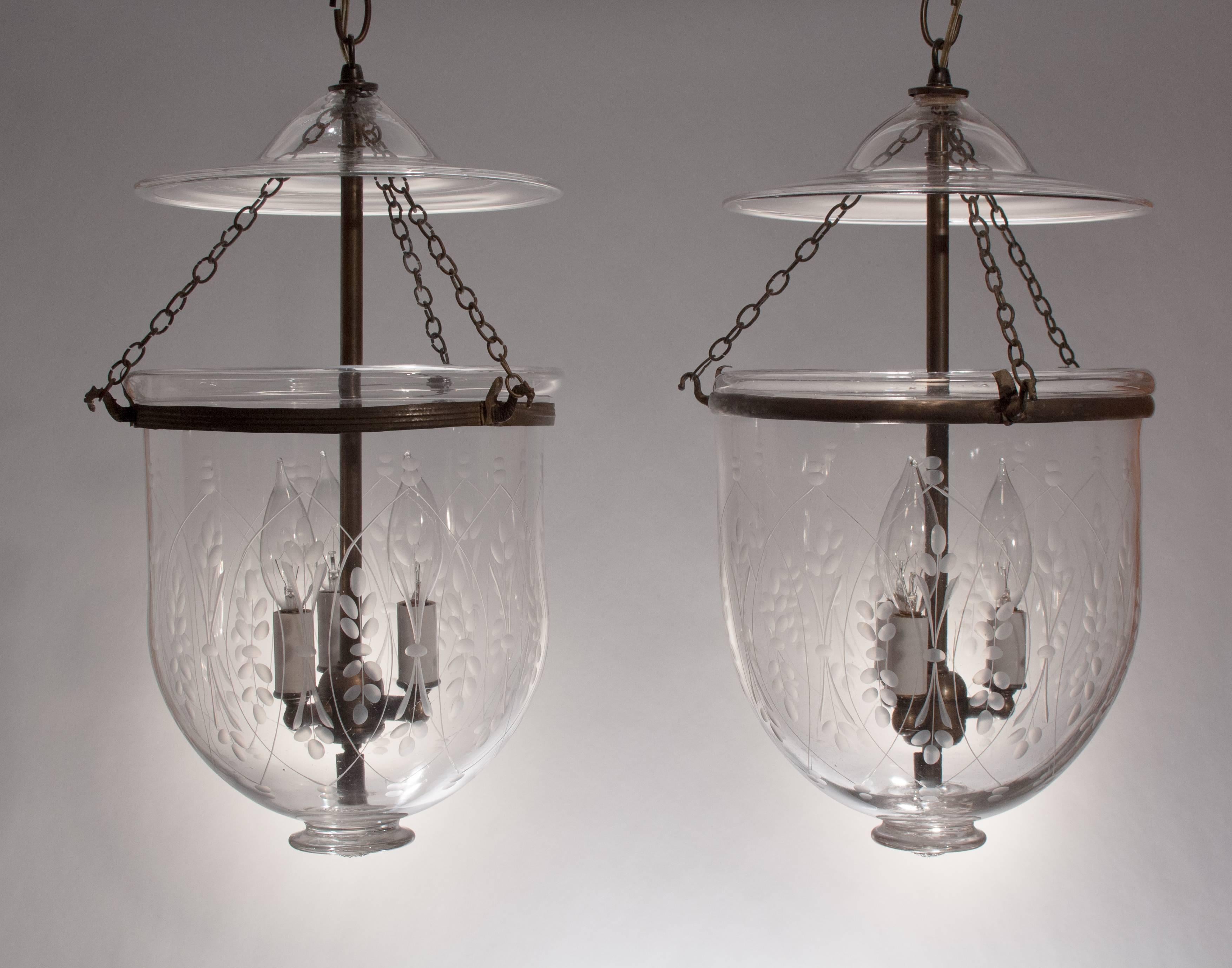 Charming pair of 19th century English hand blown glass bell jar lanterns with a finely etched wheat design that complements the full form of these hall lanterns. The bell jar lights, which feature their original smoke bells and chain, have been  