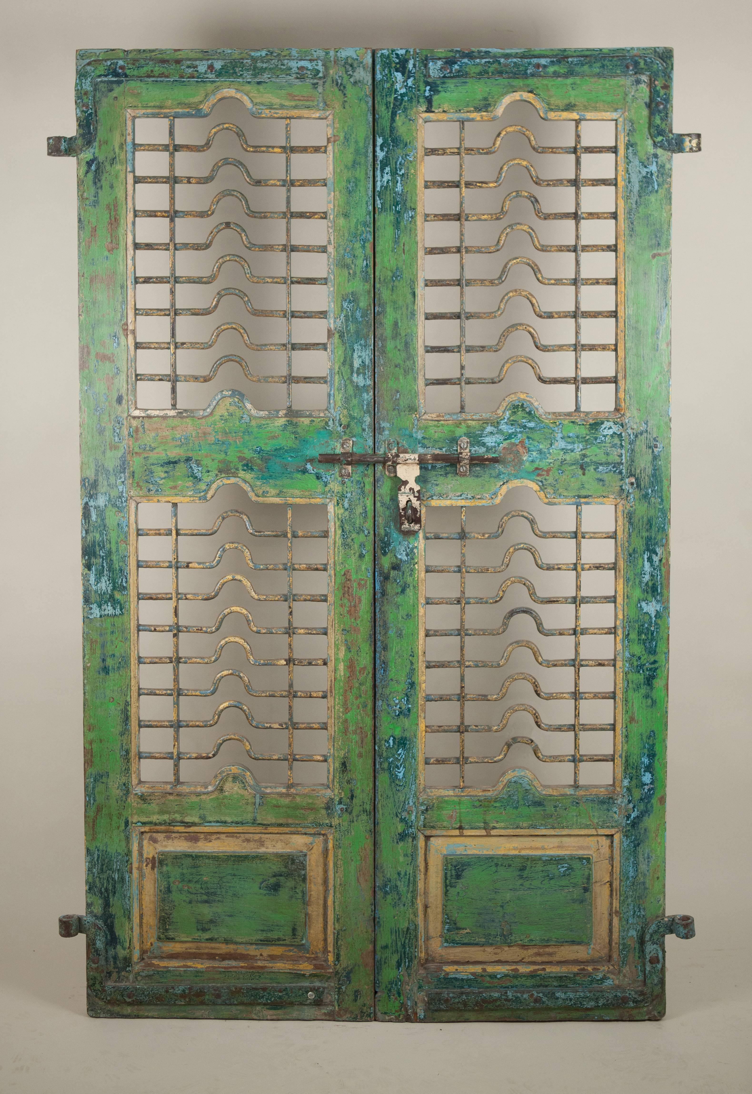 Colorful teak wood and iron door from Gujarat, India, circa 1900. This green-blue courtyard gate features original paint and hand forged ironwork, including a sliding lock on one side. Interior, terrace and landscape design possibilities abound.