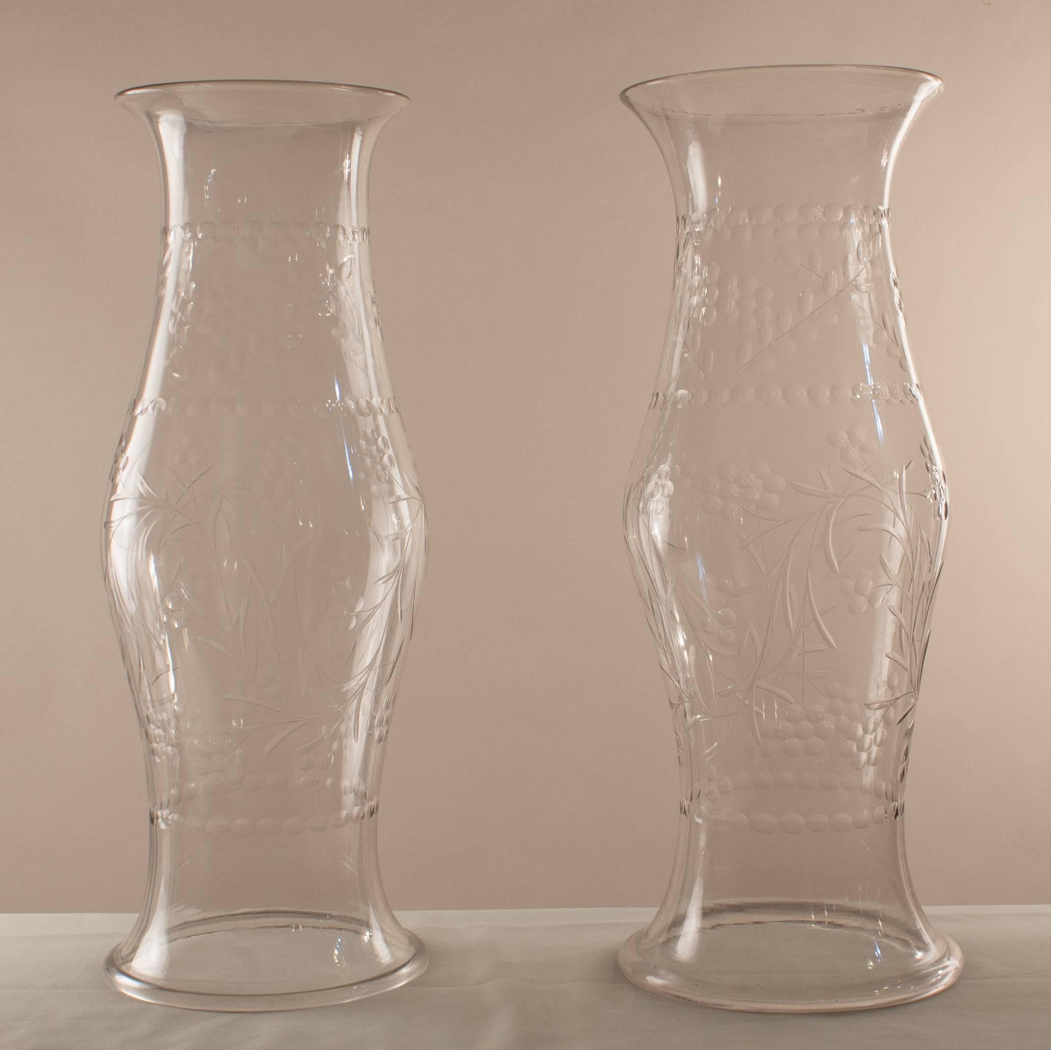 A rare pair of English handblown glass hurricane shields with exquisite form and a finely etched vine and floral design that is the perfect complement to these 19th century shades. The shields, which shelter candles or candlesticks, are in excellent