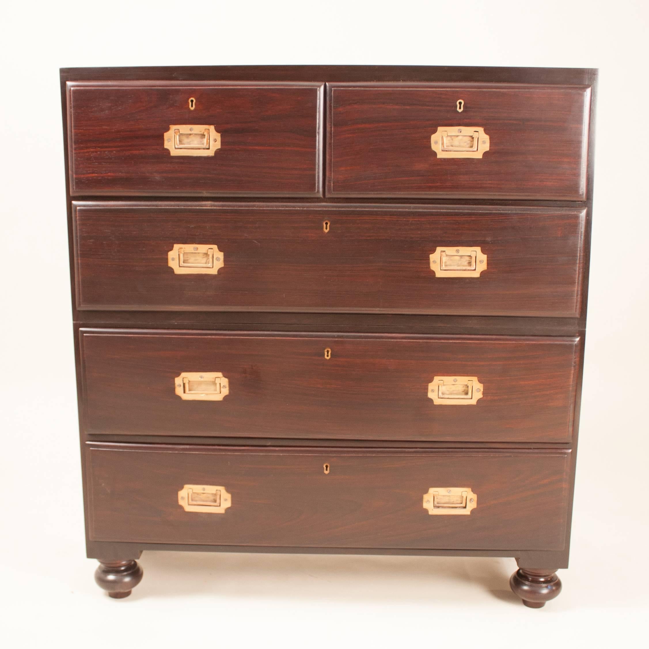 Petite British Colonial Campaign chest of drawers, circa 1920, in solid rosewood with inset brass drawer pulls. This classic dresser, which is in two parts for ease of transport, has been attentively restored. Each of the five drawers slides