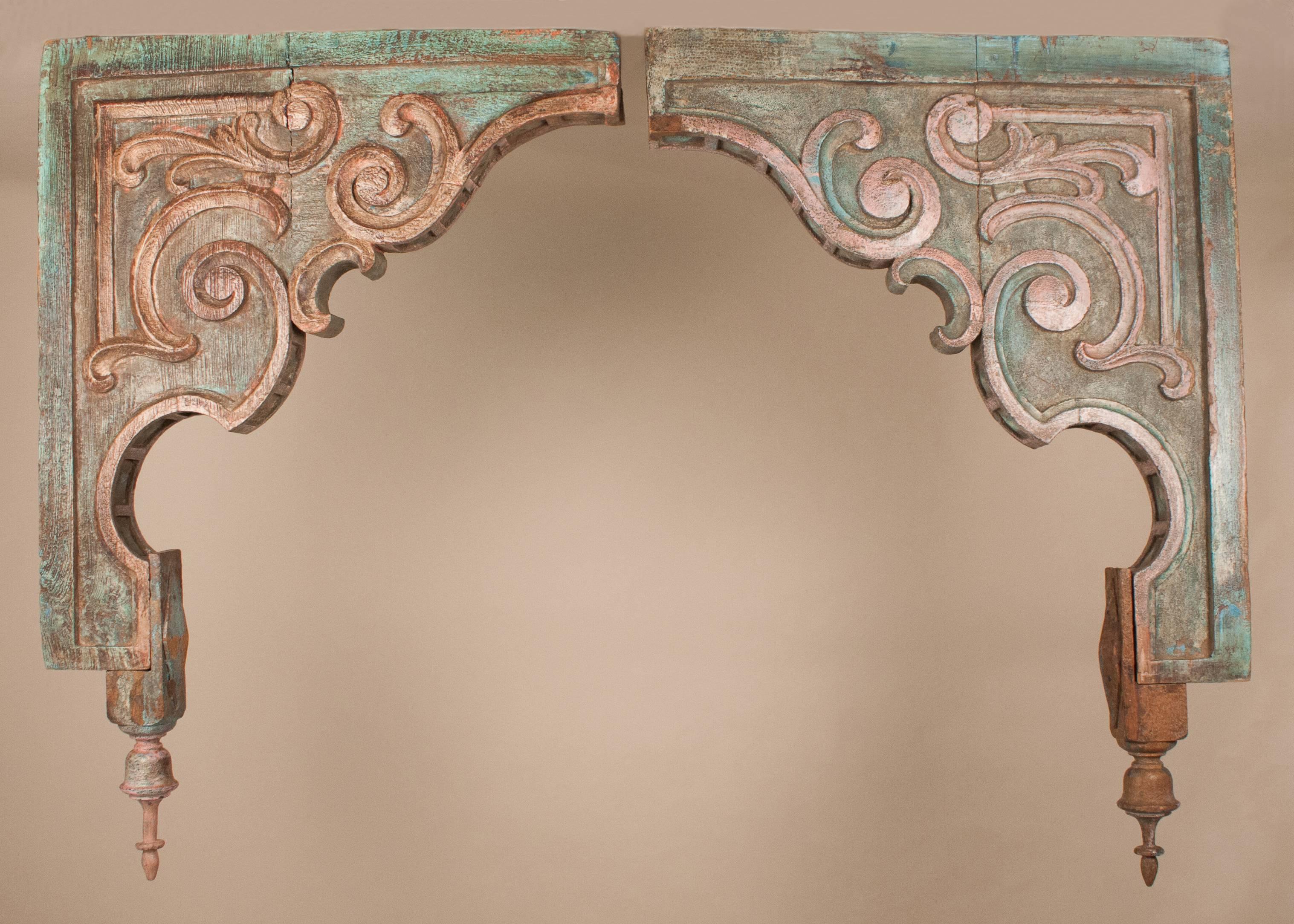 Pair of large teak wood corbels from a Gujarati haveli in India. These colorful architectural treasures have a distinctly rustic appeal, including their original paint and subtle variations in the hand carving of each of the corbels, circa 1930.